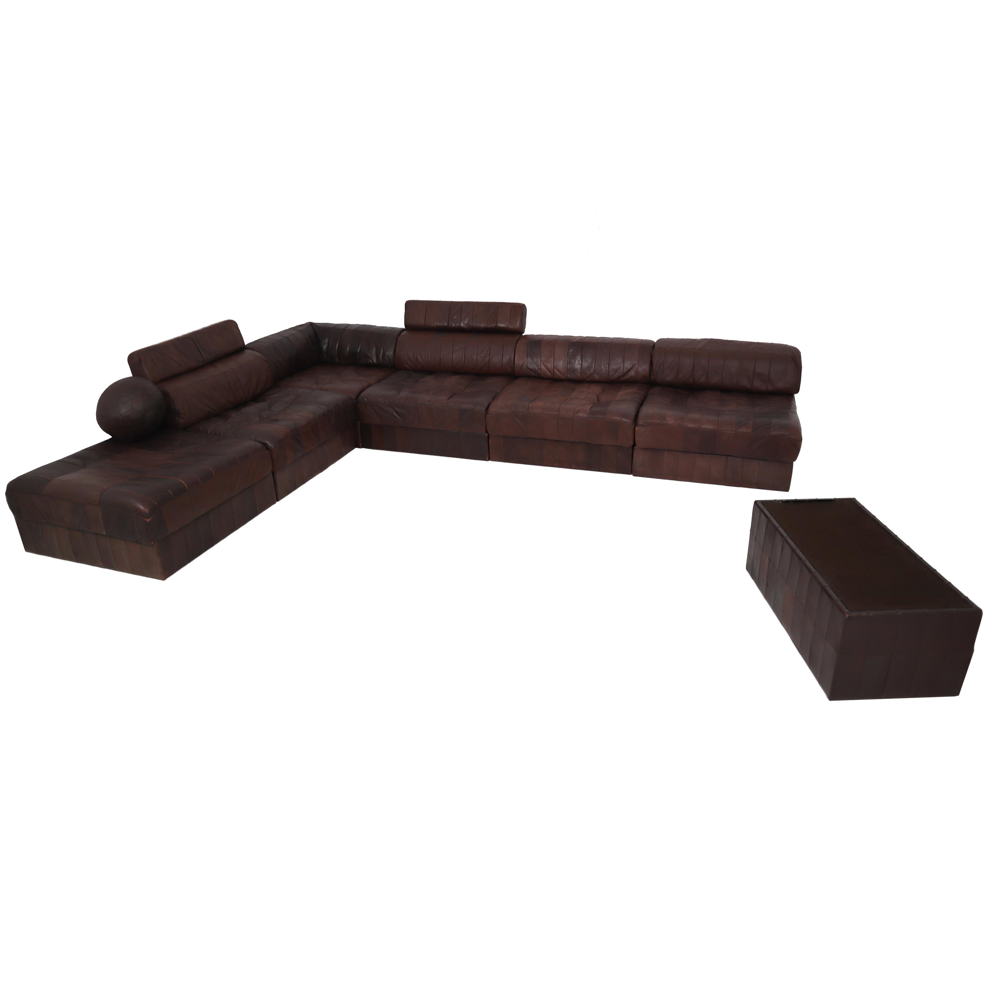 We are delighted to bring to you an original and extremely desirable De Sede DS 88 sectional sofa in patchwork brown-cognac aniline leather with bolster cushions. Hand built in the 1970s to incredibly high standards by De Sede craftsman in