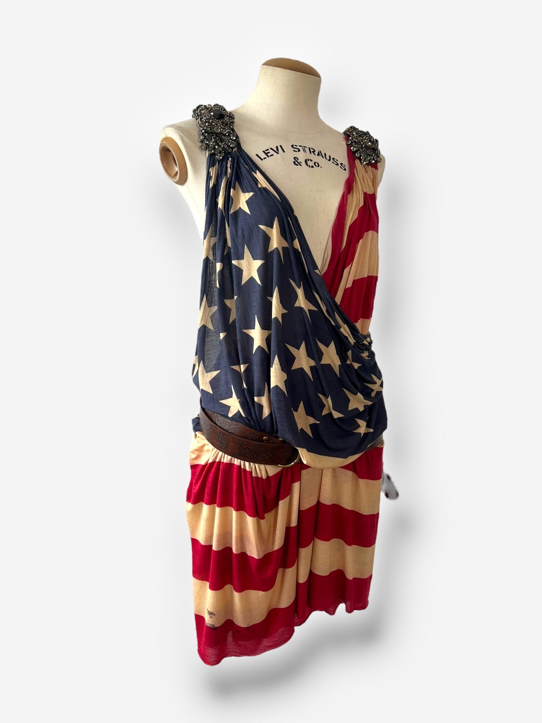 

Draped in bold Americana, this Dsquared² dress from the Spring/Summer 2013 collection makes a dramatic statement with its fluid flag print and sculptural drape. The silhouette is loose and open, worn as a true wrap style with no built-in closures.