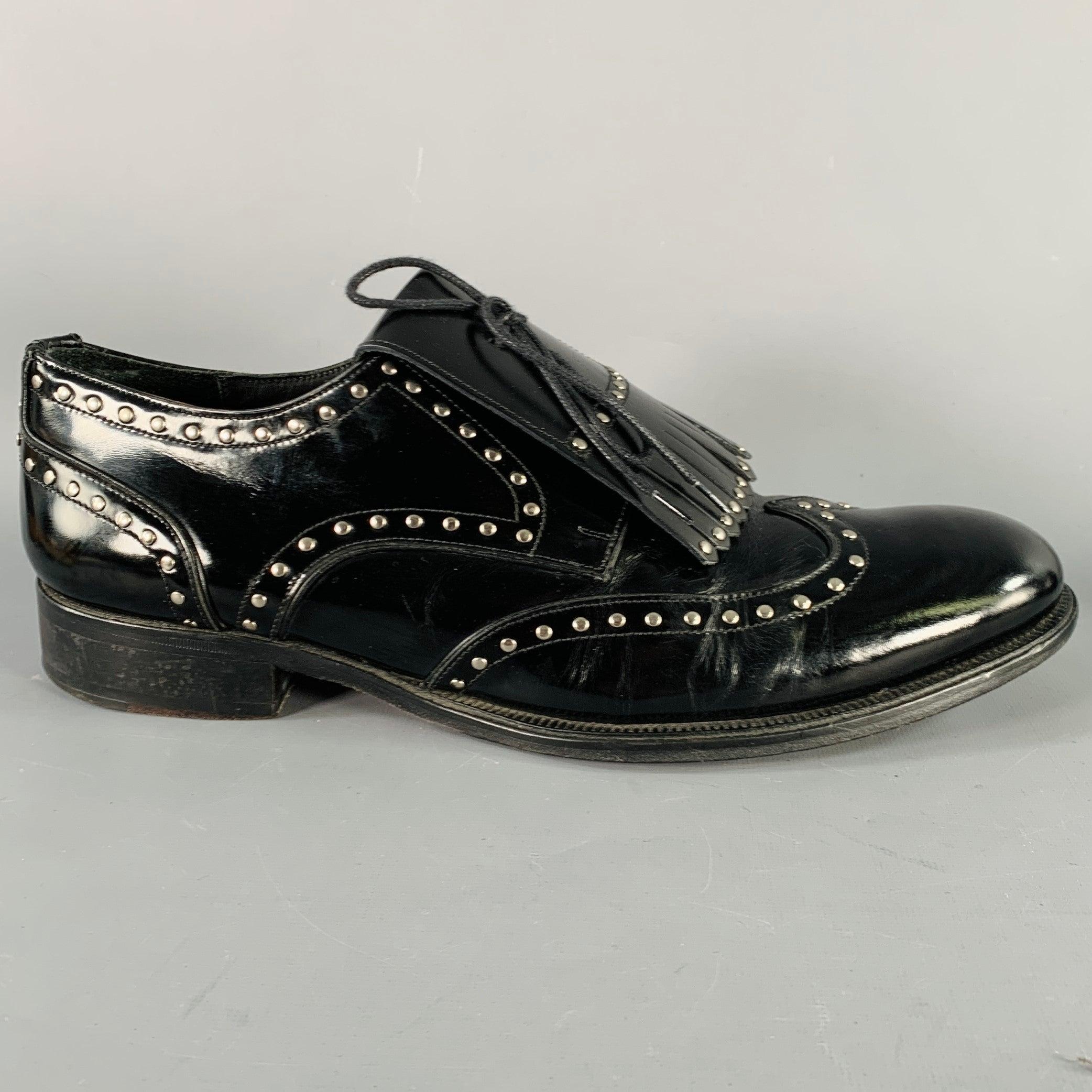 DSQUARED2 shoes in a black patent leather featuring an all over silver tone metal studded design, removable moccasin fringe, and lace-up closure. Comes with dust bag. Made in Italy.Very Good Pre-Owned Condition. Moderate creasing. 

Marked:   IT