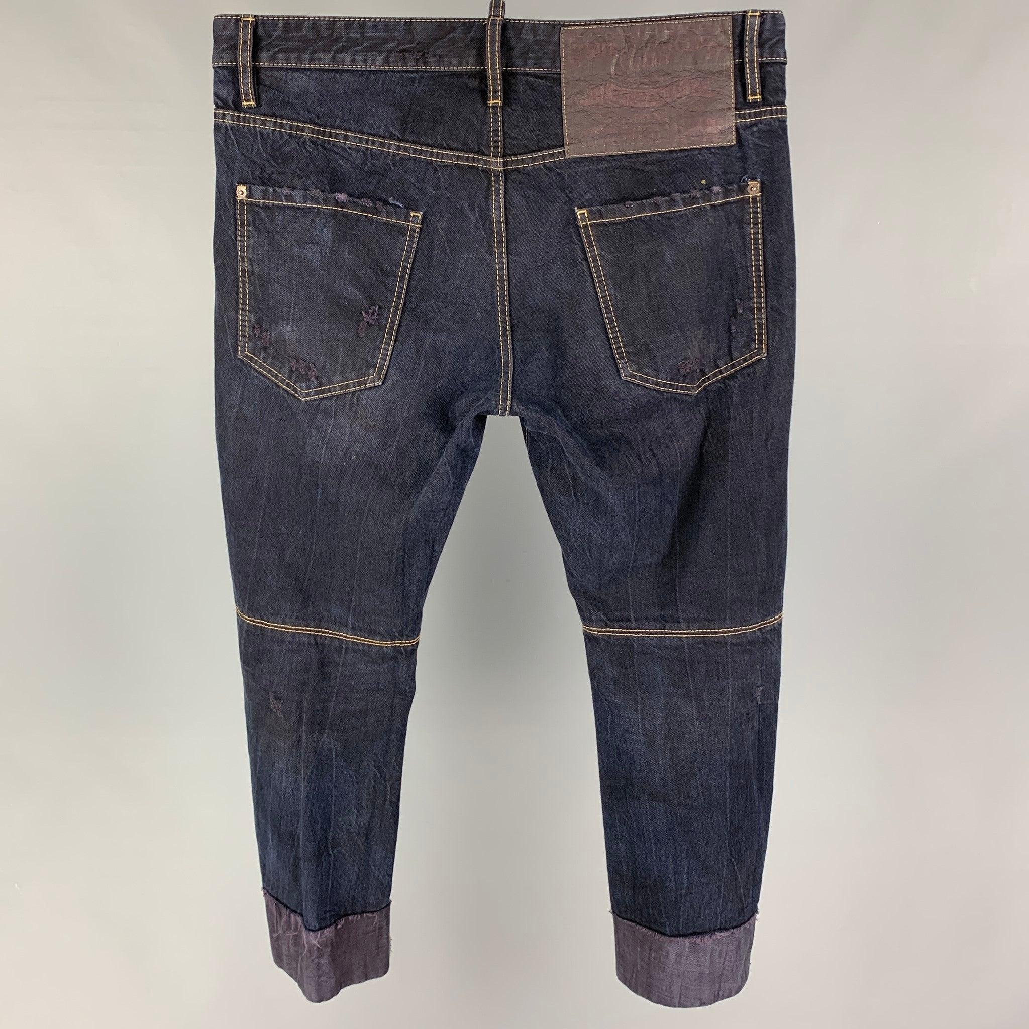 DSQUARED2 jeans comes in a dark navy distressed cotton featuring cropped style, contrast stitching, and a button fly closure. Made in Italy.
Good
Pre-Owned Condition. 

Marked:   50 

Measurements: 
  Waist: 36 inches  Rise: 11 inches  Inseam: 26
