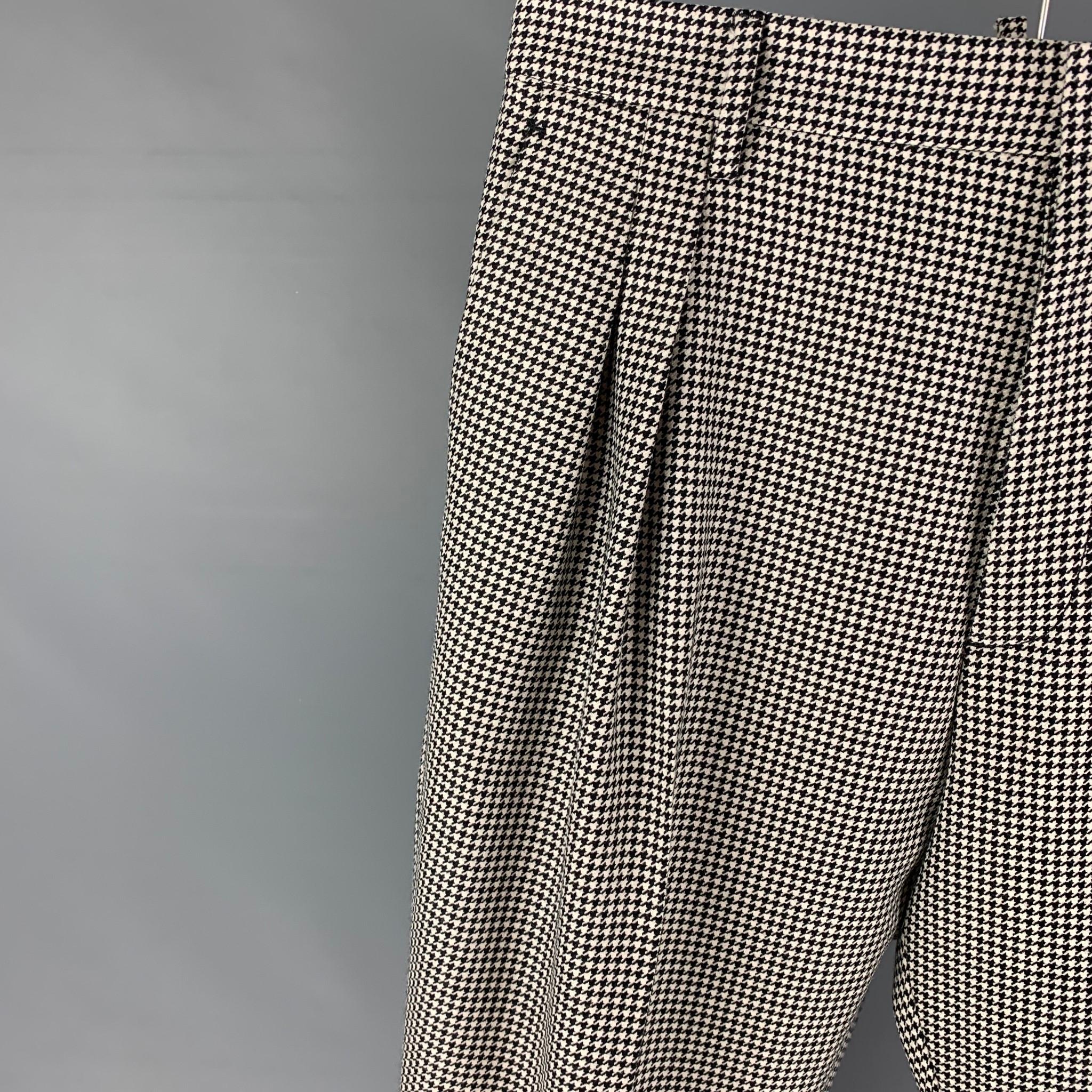 DSQUARED2 dress pants comes in a black & white houndstooth lana wool featuring a pleated style, high waisted, cuffed leg, front tab, and a button fly closure. Made in Italy. 

Very Good Pre-Owned Condition. Minor repair at leg. As-is.
Marked: IT 52