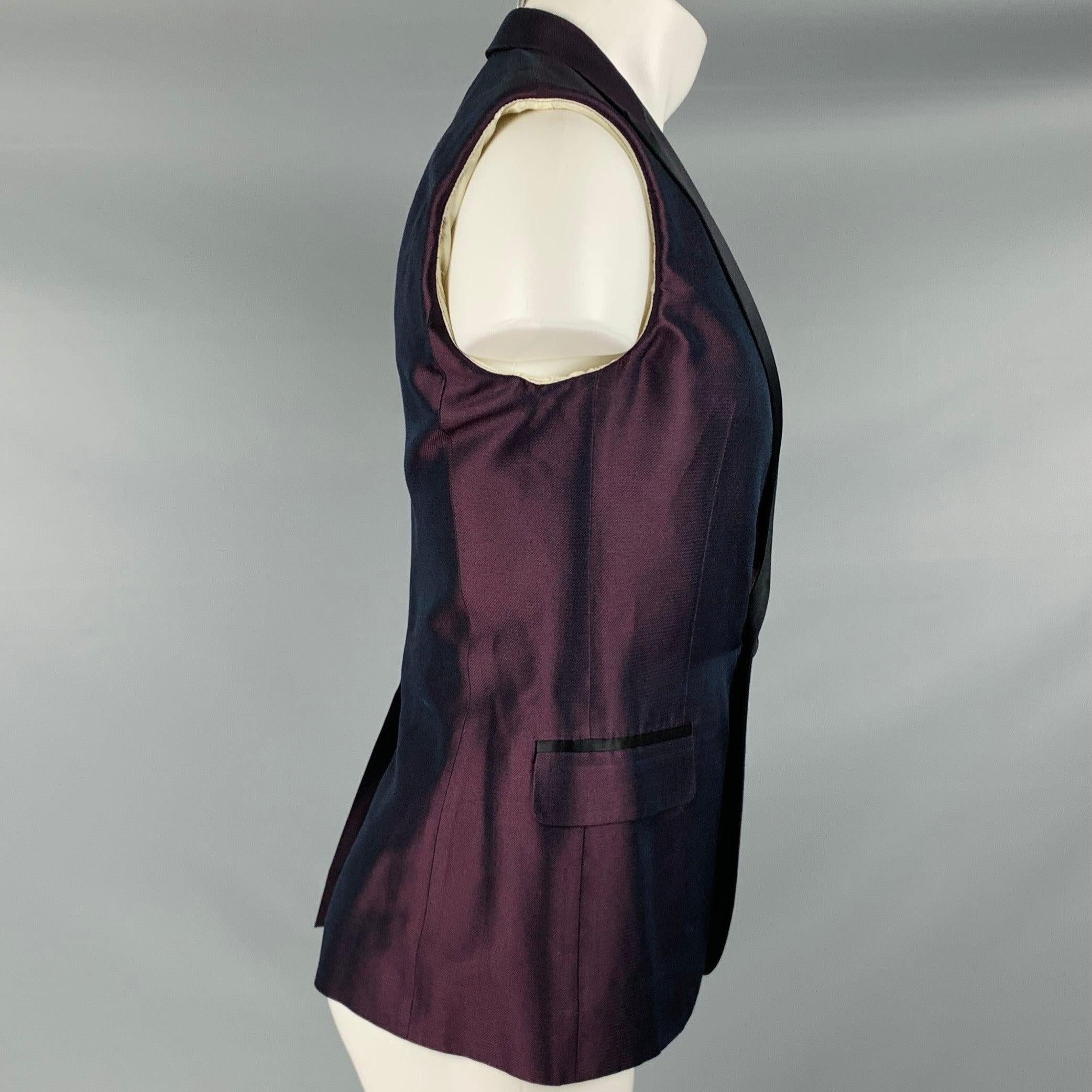 DSQUARED2 vest
in a purple silk fabric featuring black contrast peak lapel, and single button closure. Made in Italy. Note: this item was professionally altered into a vest from a sport coat. Please check measurements.Very Good Pre-Owned Condition.