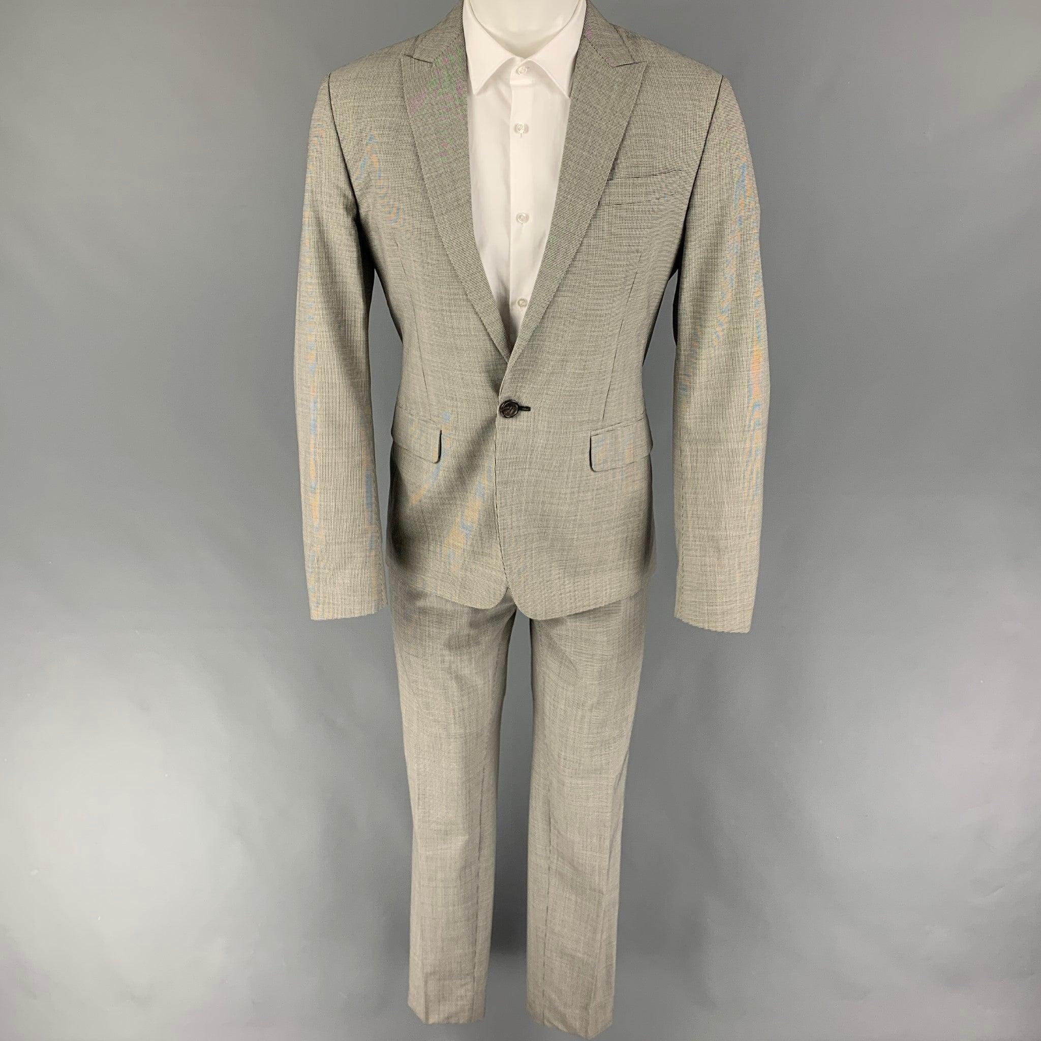 DSQUARED2
suit comes in a black & white houndstooth wool with a full liner and includes a single breasted, single button sport coat with a peak lapel and matching flat front trousers. Made in Italy. Very Good Pre-Owned Condition. 

Marked:   50