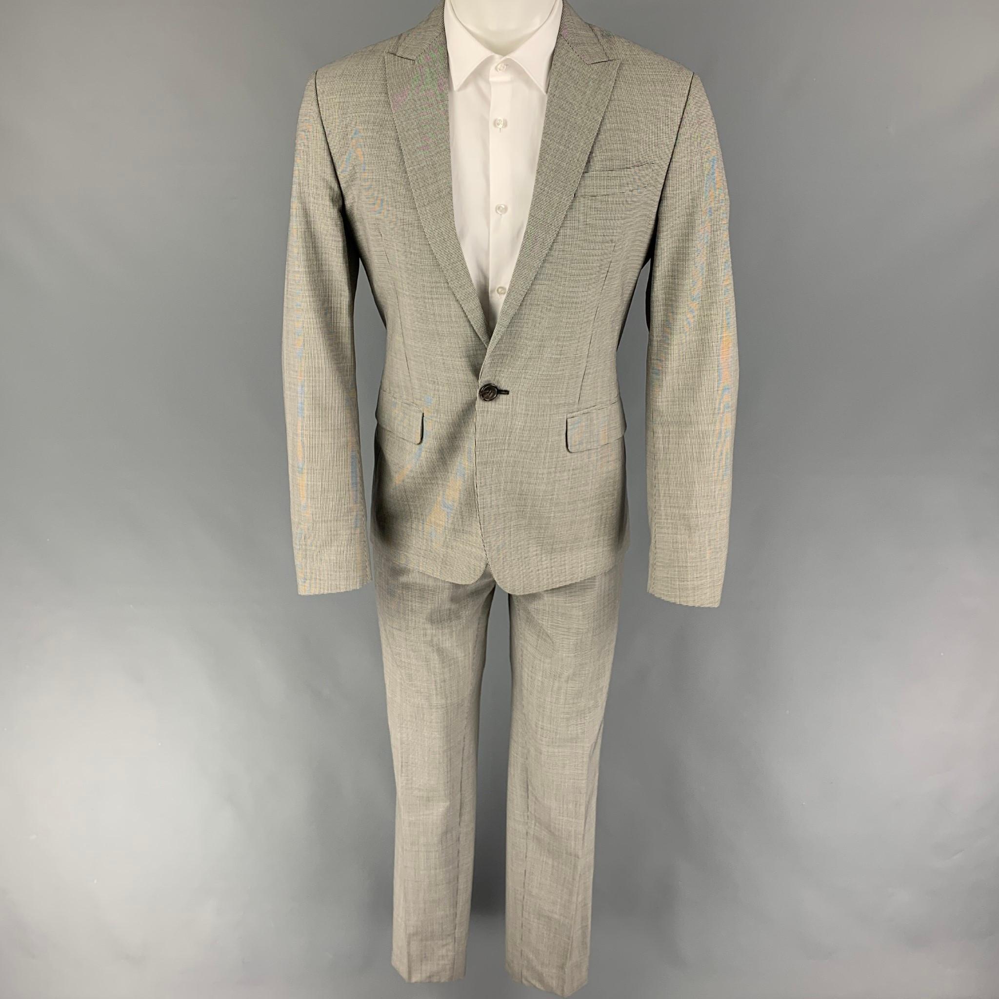 DSQUARED2 suit comes in a black & white houndstooth wool with a full liner and includes a single breasted, single button sport coat with a peak lapel and matching flat front trousers. Made in Italy.

Very Good Pre-Owned Condition.
Marked: