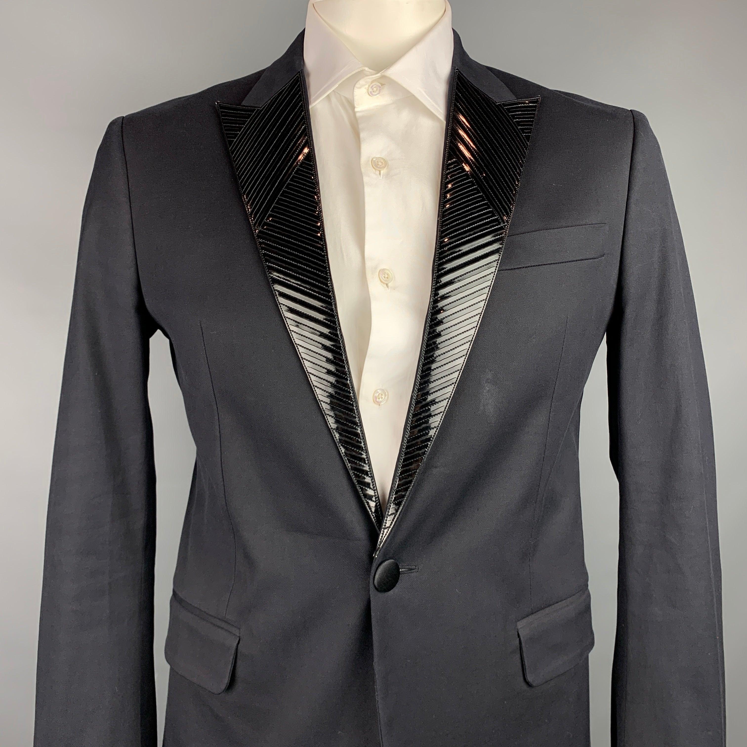 DSQAURED2
sport coat comes in a black cotton with a full monogram print liner featuring a patent leather peak lapel, flap pockets, and a single button closure. Made in Italy.Very Good Pre-Owned Condition. 

Marked:   52 

Measurements: 
 
Shoulder: