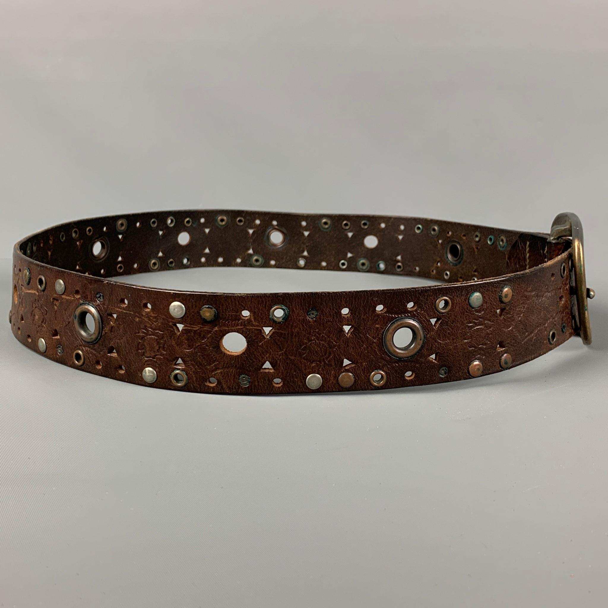 DSQUARED2 belt comes in a brown perforated leather featuring studded details and a buckle closure. Made in Italy. 

Good Pre-Owned Condition. Minor wear.
Marked: M

Length: 43 in.
Width: 1.5 in.
Fits: 36 in. - 40 in.
Buckle: 3.25 in. 