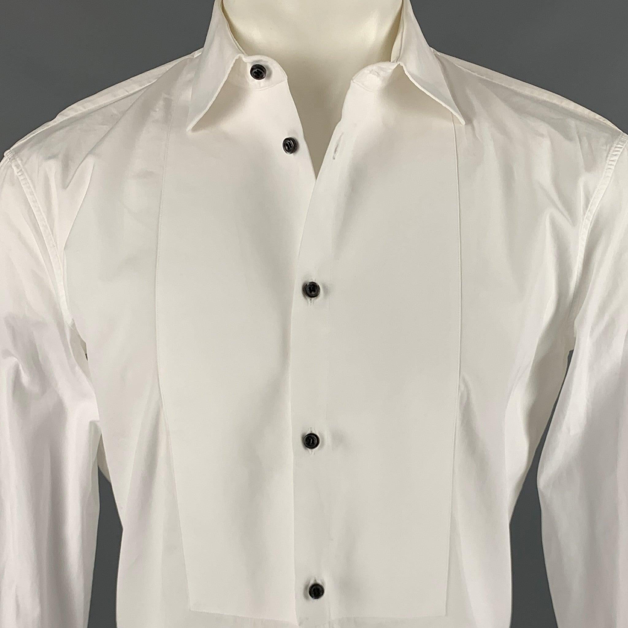 DSQUARED2 long sleeve tuxedo shirt
in a white cotton fabric featuring bib front, French cuffs, and a button closure. Cuffs come with buttons. Made in Italy.Very Good Pre-Owned Condition. Minor signs of wear. 

Marked:   48 

Measurements: 
