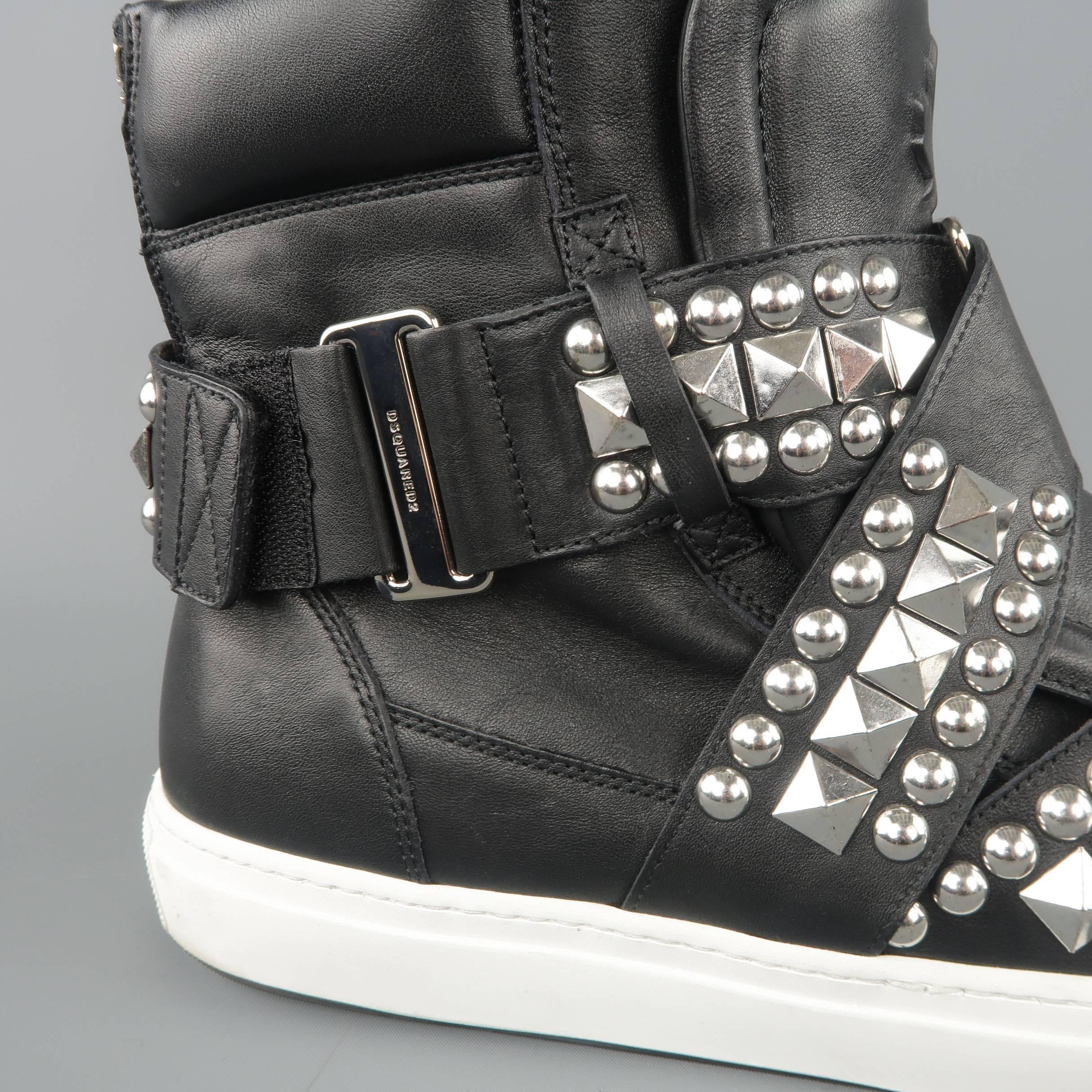 DSQUARED2 high top sneakers come in smooth black leather with a maple leaf embossed tongue, white rubber sole, and silver tone studded velcro harness straps. With box. Made in Italy.
 
Excellent Pre-Owned Condition.
Marked: IT 43
 
Outsole: 12 x 4