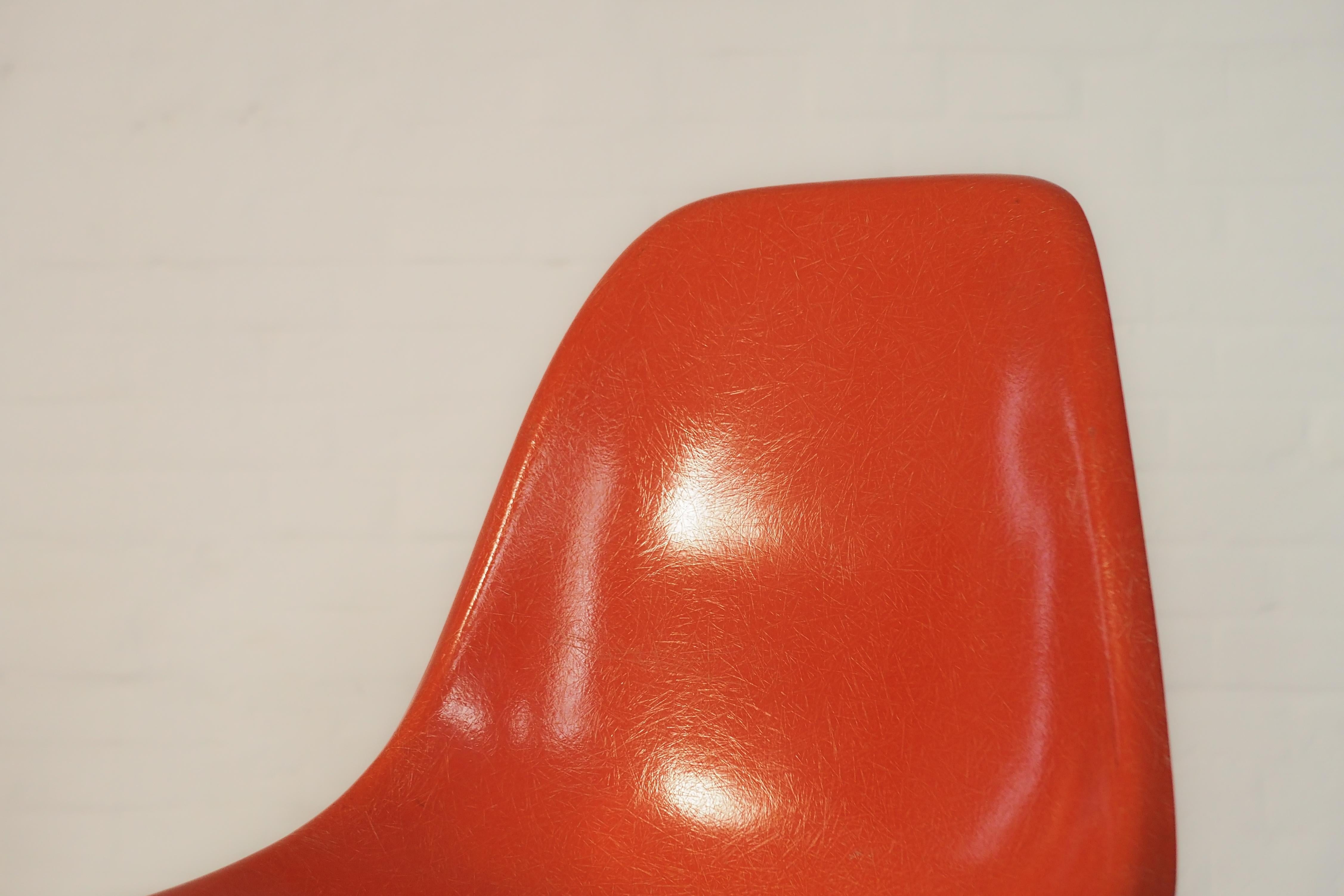 Herman Miller DSW Chair von Charles & Ray Eames - eine echte Design-Ikone des 20. Jahrhunderts. Es handelt sich um eine originale orangefarbene Fiberglasschale mit einem Sockel aus Walnussholz, der auf der Unterseite den Stempel des Herstellers