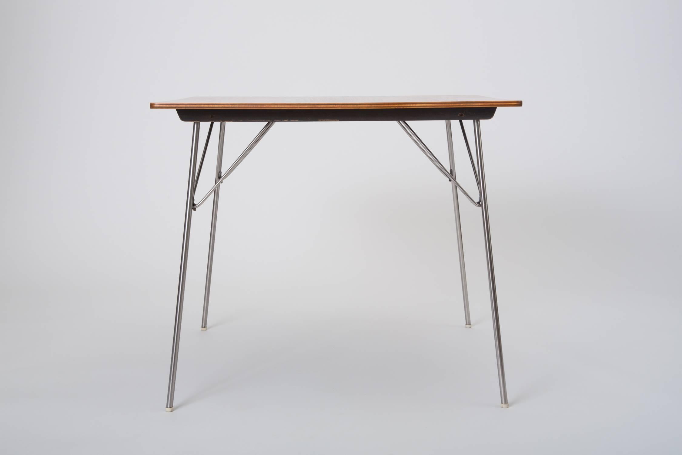 A square dining table with walnut veneered surface and folding metal legs, designed by Ray and Charles Eames and produced by Herman Miller. Dubbed the DTM-20 (“Dining Table Metal”), this example was part of a series of tables introduced in 1947,