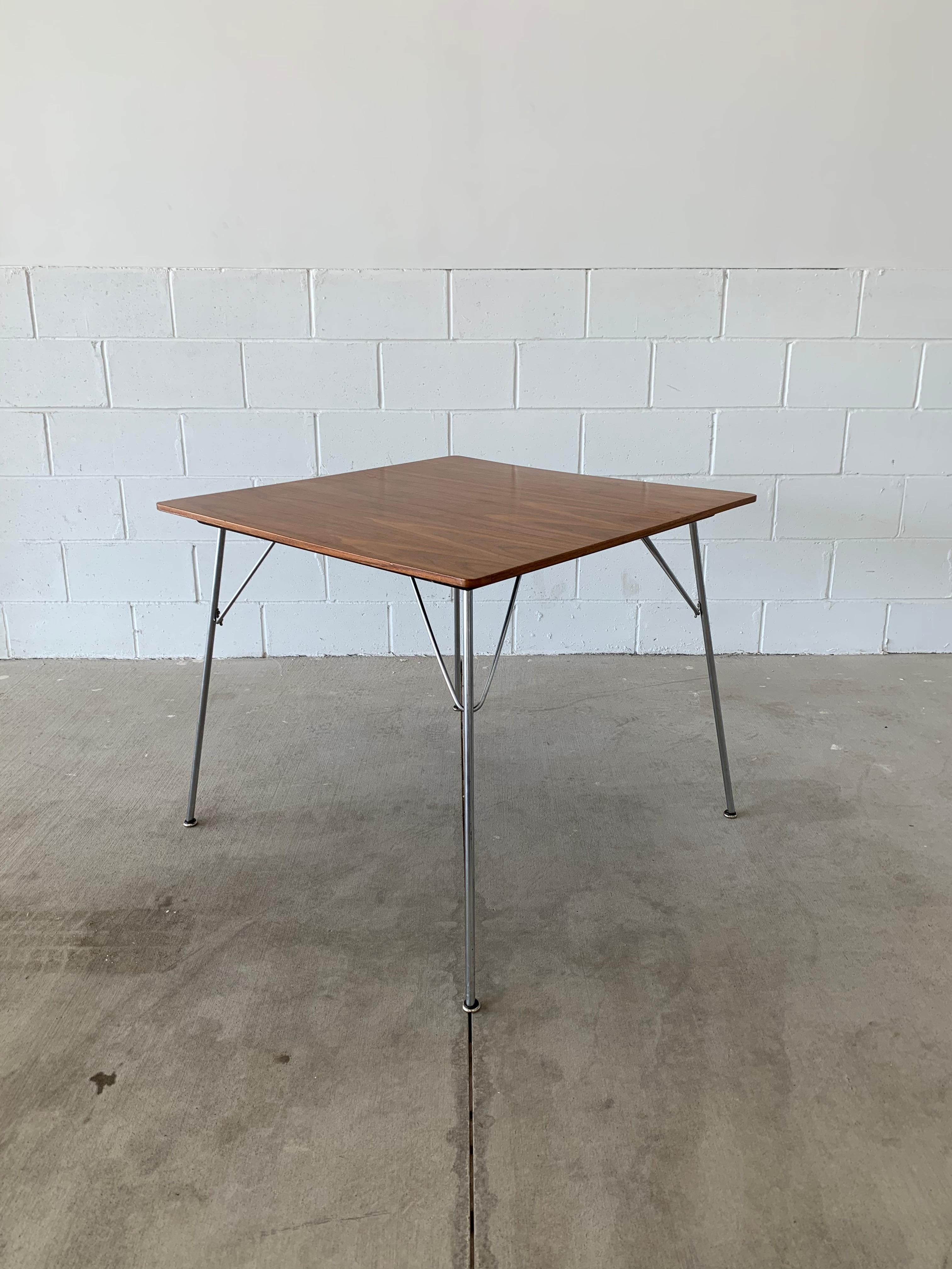 Cette magnifique table Vintage By By par Ray et Charles Eames est un ajout magnifique à toute maison ou bureau. Fabriqué par Herman Miller, il est constitué d'un plateau en noyer, d'un dessous peint en noir et de pieds en métal poli avec les 
