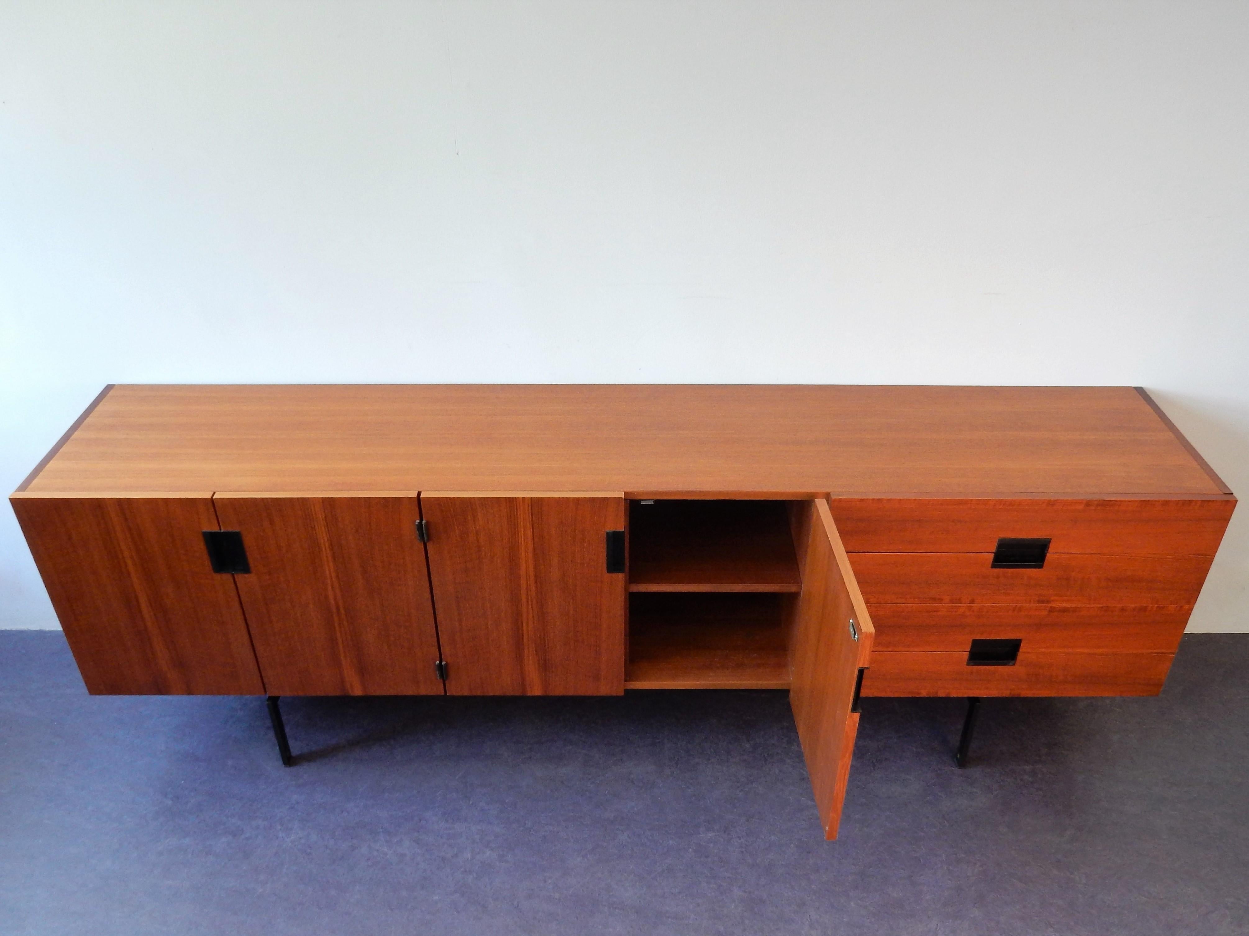 This iconic sideboard, model DU03, is a beautiful piece of design from the Japanese series by Cees Braakman for Pastoe. The cabinet is made of teak veneer and has the iconic black integrated handles and a minimalistic black metal base. It has 2