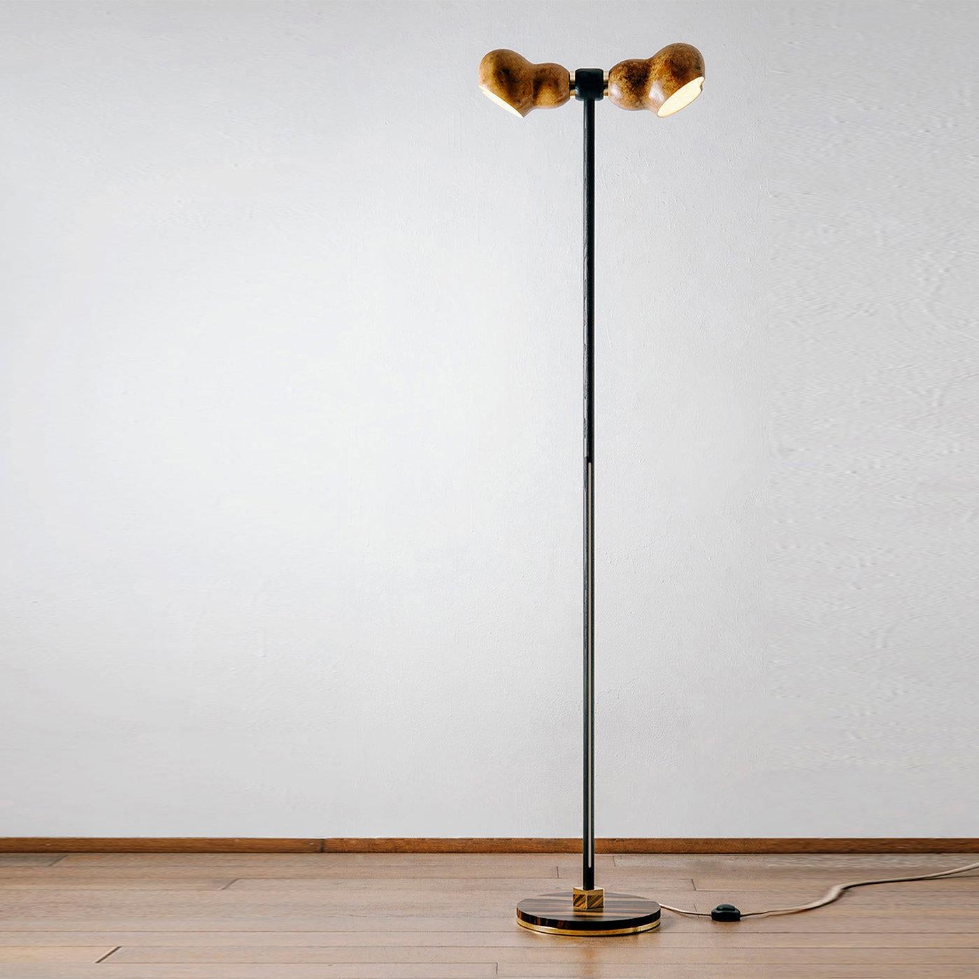 Dual is an elegant sustainable floor lamp made of water-painted ash wood, dried Lagenaria gourd and recycled copper. Its peculiarity is the harmony resulting from the sinuous and soft lines of the lamp. The supporting structure is enlivened by the