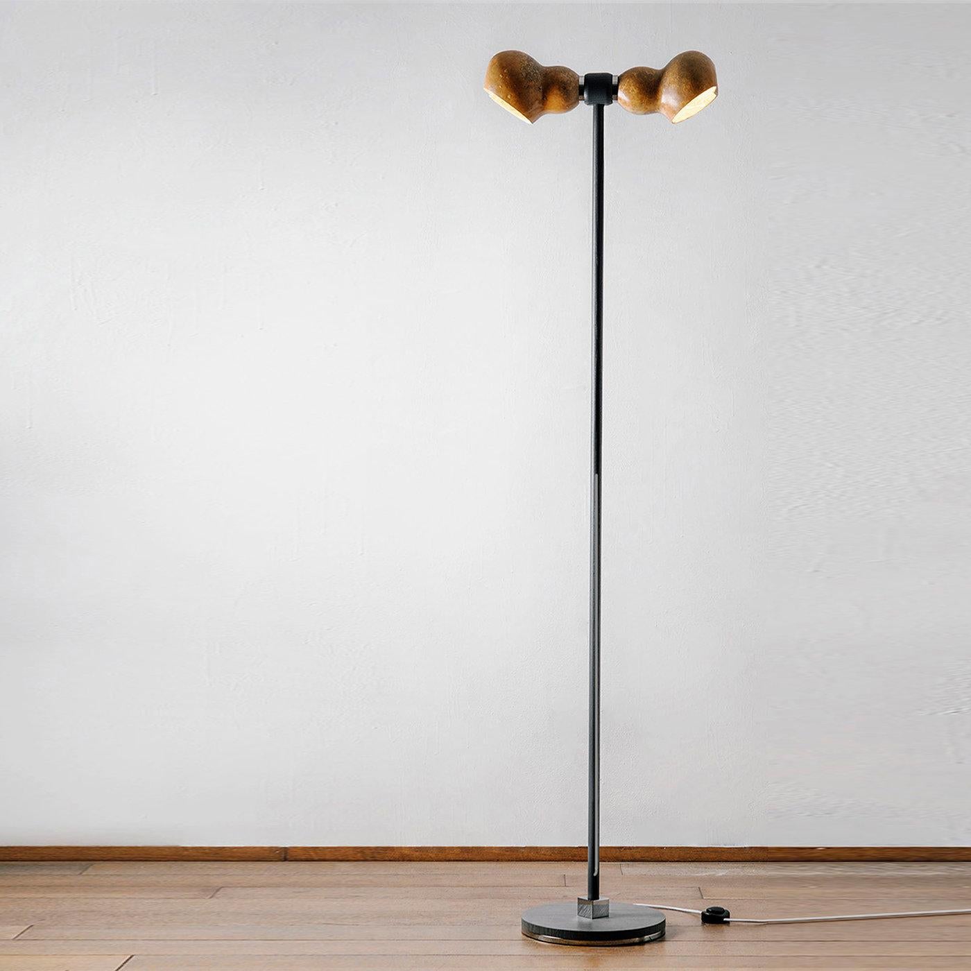 Dual is an elegant sustainable floor lamp made of water-painted ash wood, dried Lagenaria gourd and recycled copper. Its peculiarity is the harmony resulting from the sinuous and soft lines of the lamp. The supporting structure is enlivened by the