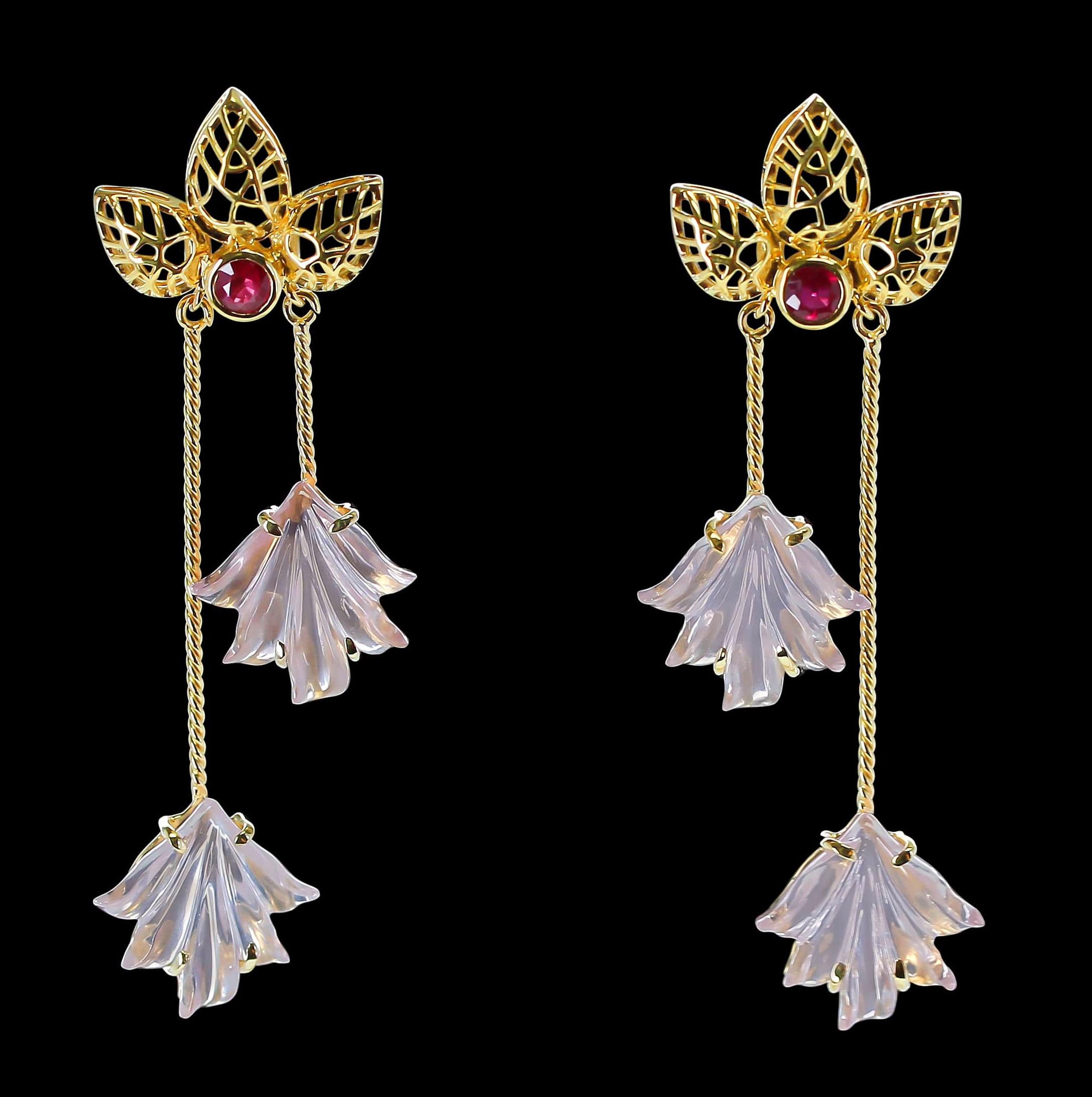 A Dual Carved Pair of Rose Quartz on each earring with intricate Gold Leaf Work on top accented with a ruby cut stone. 14K Gold, Rose Quartz Weight: 16.98 carats, Ruby Weight: 0.52 carats. L: 2 & 3/8” Metal type and stones can be customized. 