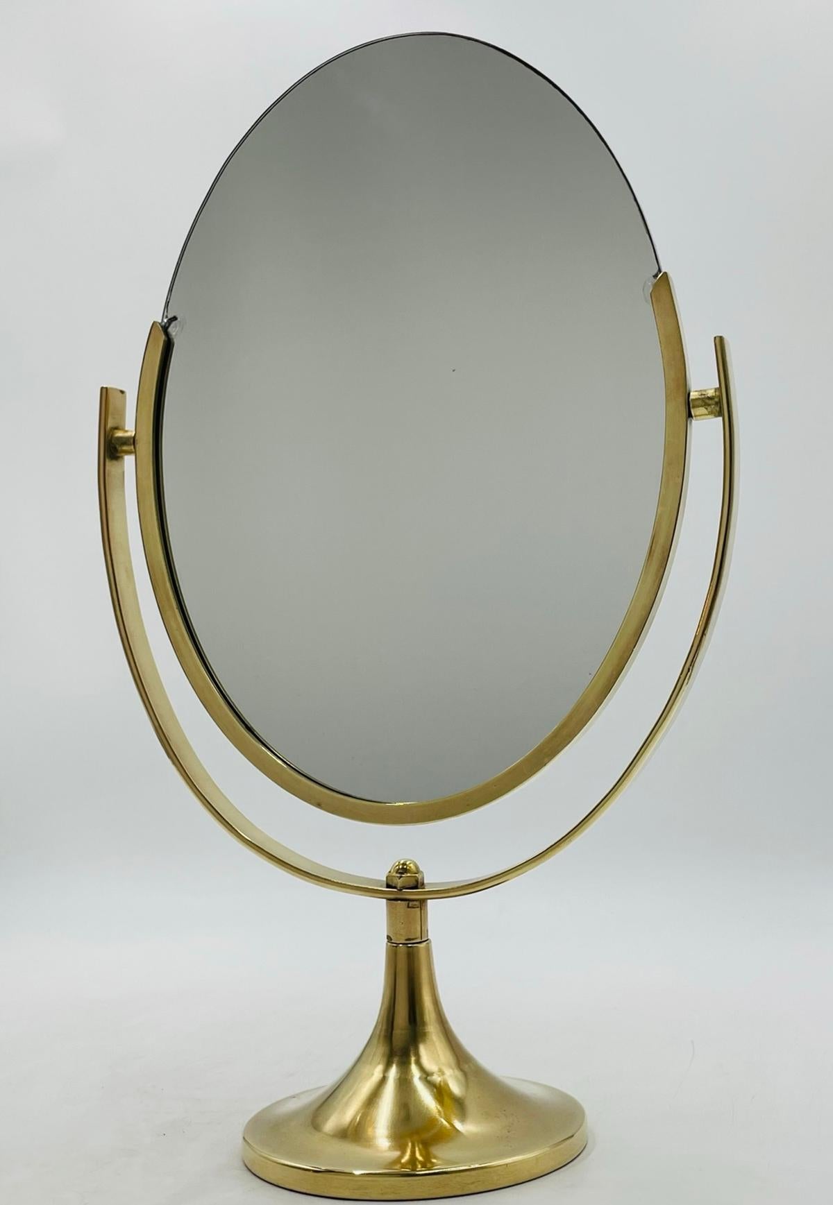 Le miroir de courtoisie double face en laiton de Charles Hollis Jones est un meuble étonnant et fonctionnel qui rehaussera n'importe quel espace. Fabriqué à l'origine aux États-Unis dans les années 1970, ce miroir est un véritable chef-d'œuvre