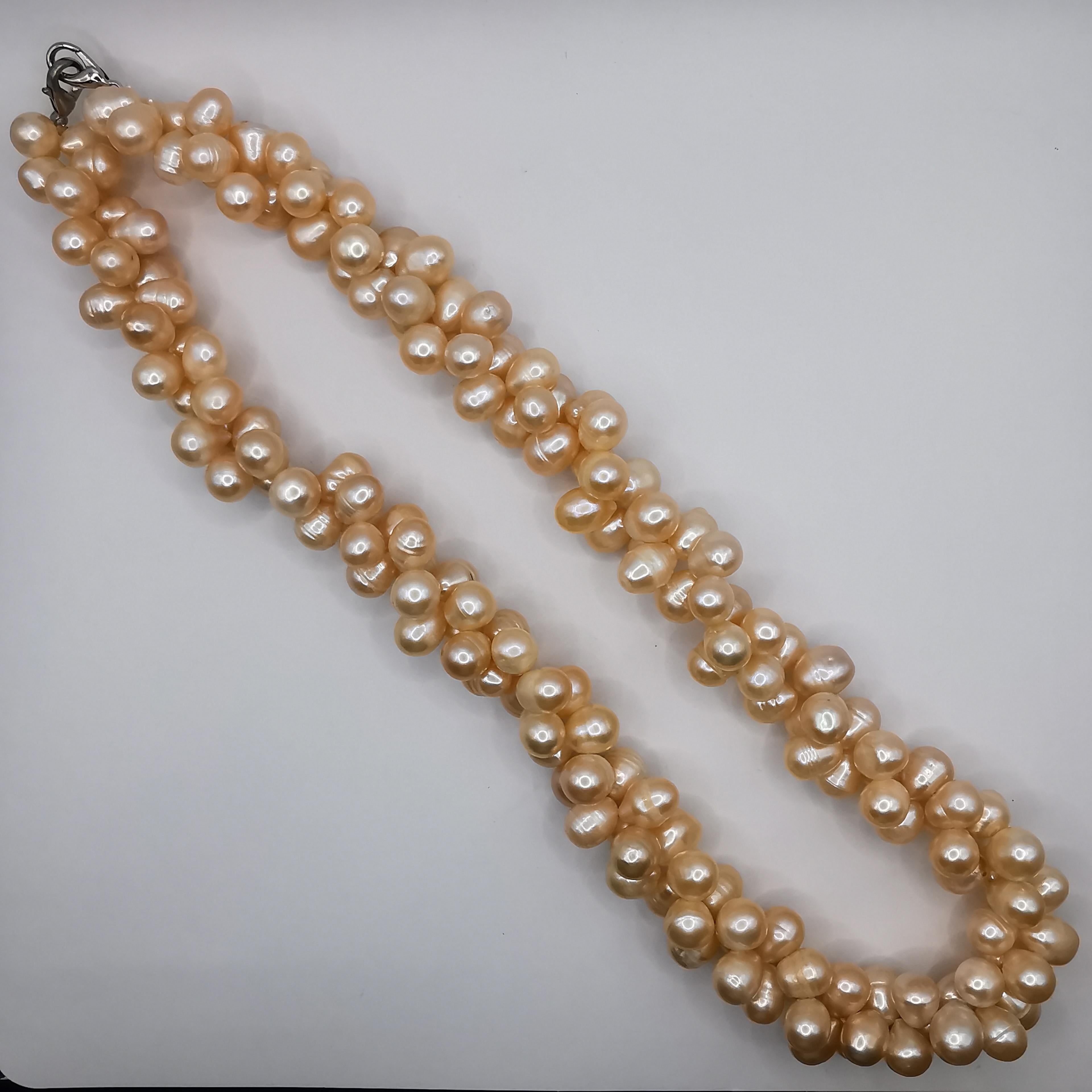 This dual twisted freshwater cultured baroque peach pearl necklace is a beautiful and elegant piece that is sure to impress. The necklace features a unique design, with two twisted strands of freshwater cultured baroque peach pearls that come