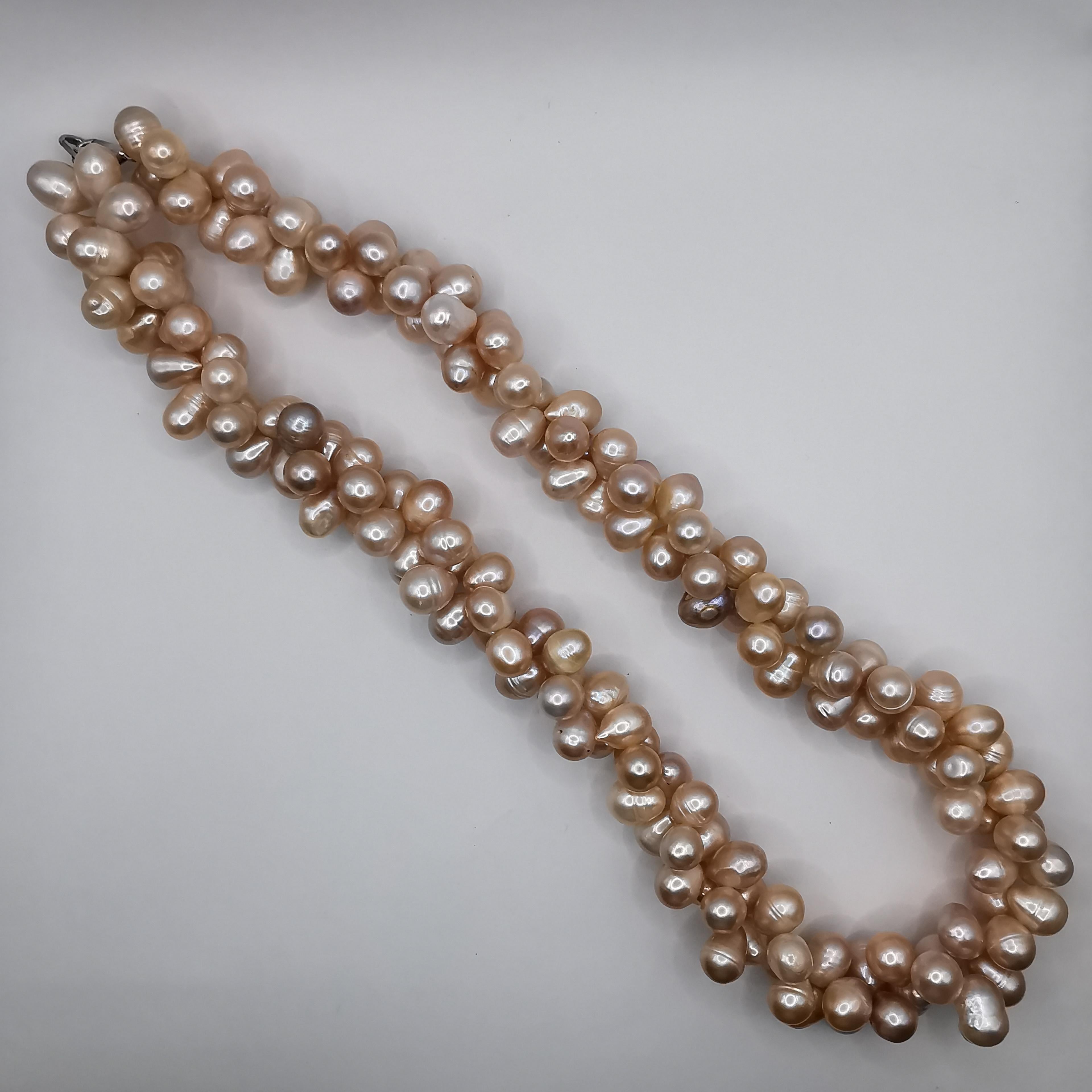 This dual twisted freshwater cultured baroque pink pearl necklace is a stunning and unique piece that is sure to catch the eye. The necklace features a beautifully twisted design, with two strands of freshwater cultured baroque pink pearls that come
