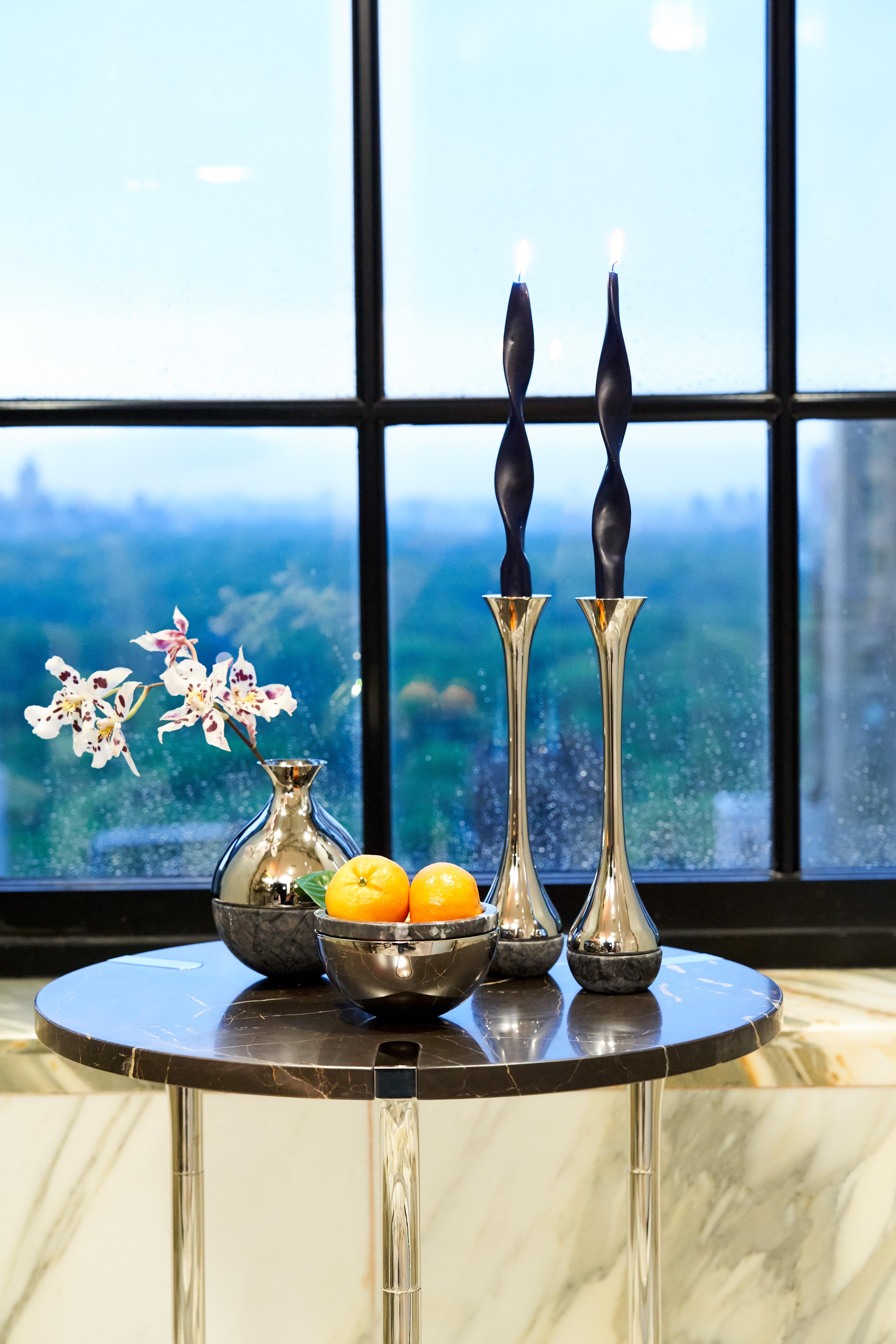 Our Dual collection unites two very different material: honed Italian marble, and polished metal. It is designed to create moments of grace: a bud-vase that holds a single stem of one's favourite flower, candlesticks that adorn the table when