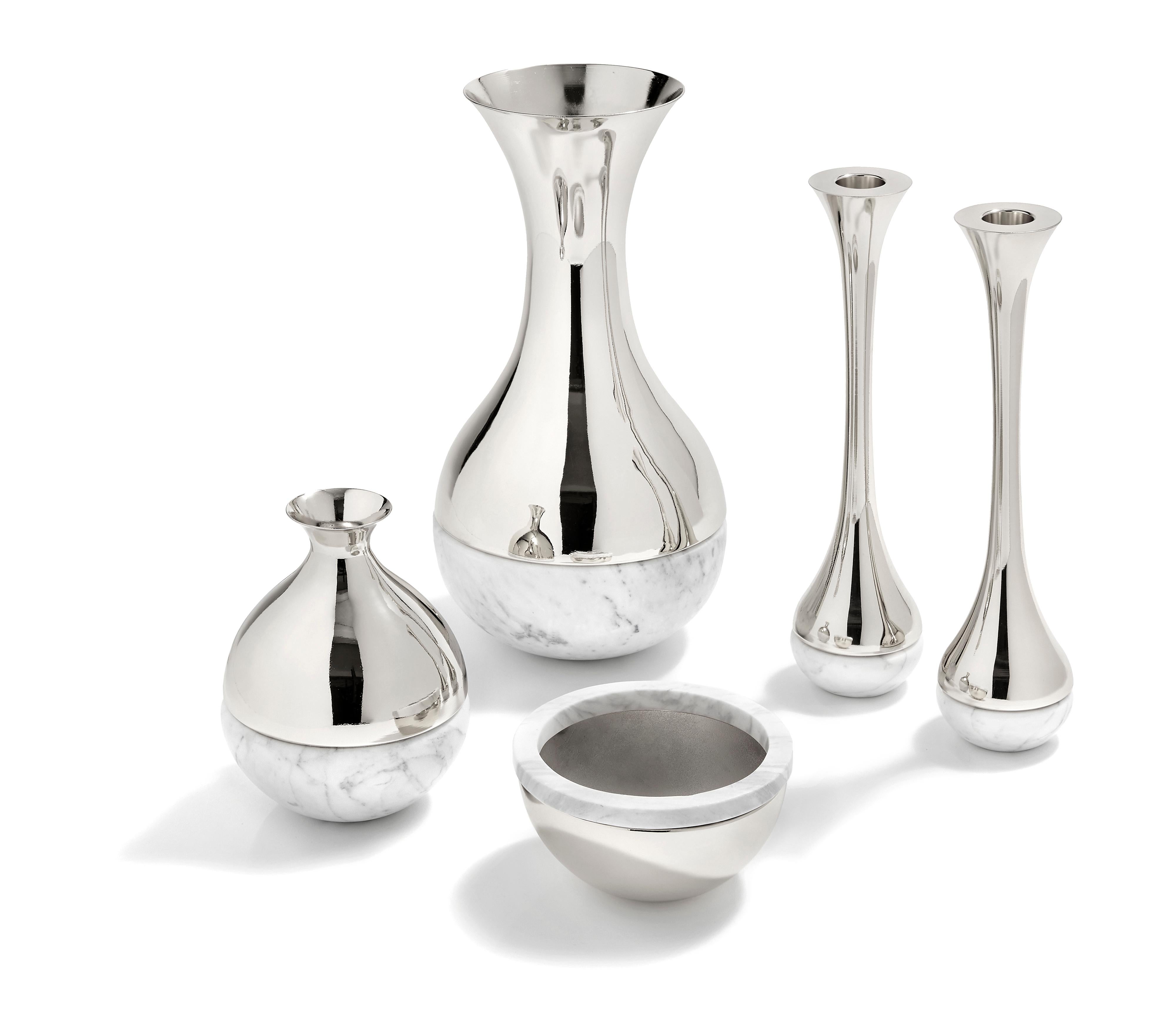 Our Dual collection unites two very different material, honed Italian marble, and polished metal. It is designed to create moments of grace: a bud-vase that holds a single stem of one's favorite flower, candlesticks that adorn the table when friends