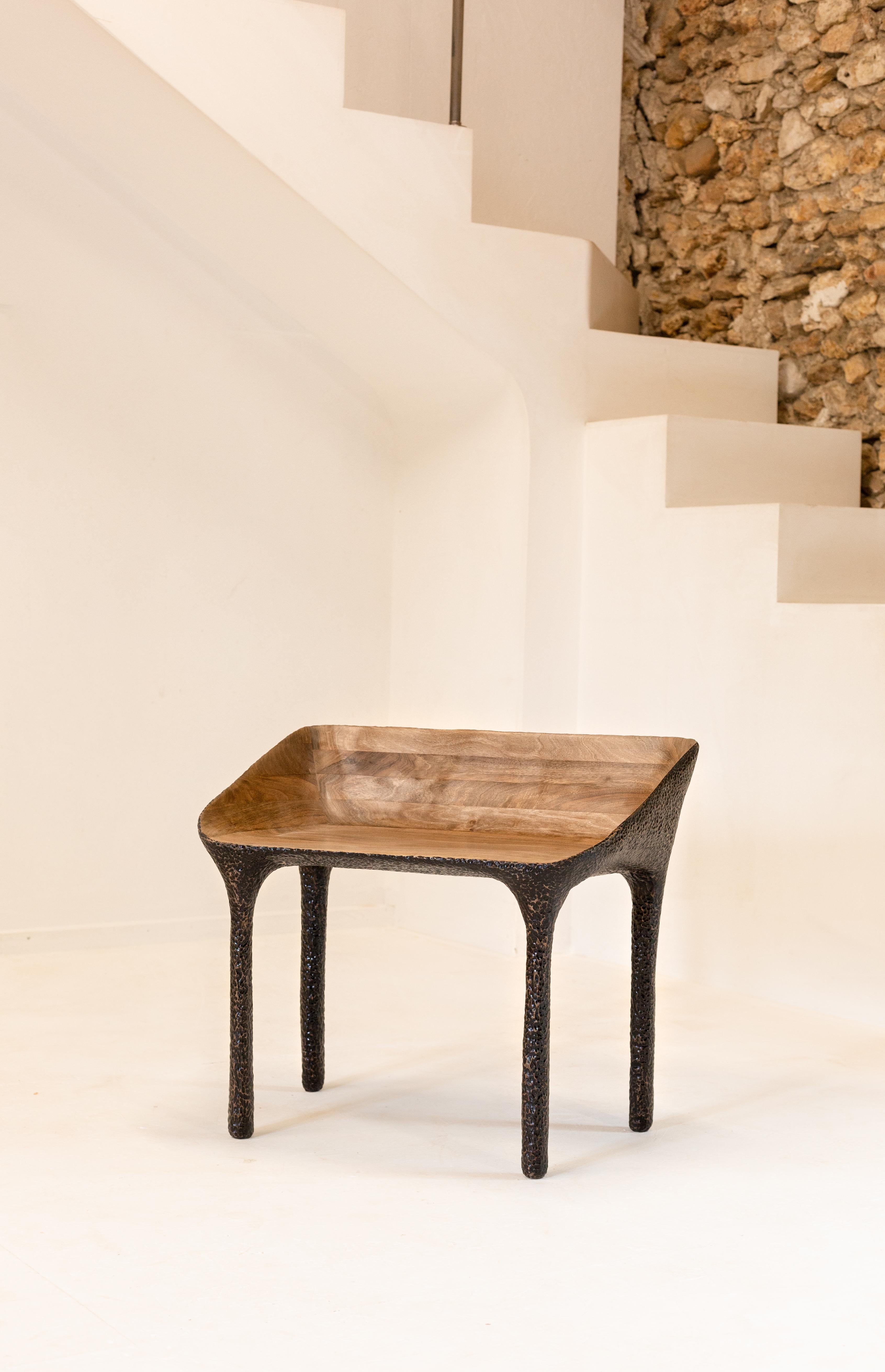 Dualités is a range of furniture and lighting that combines smooth, natural-looking carved solid wood with contrasting textured elements reminiscent of hammered metal.
These two elements come together in a single piece, with the aim of surprising