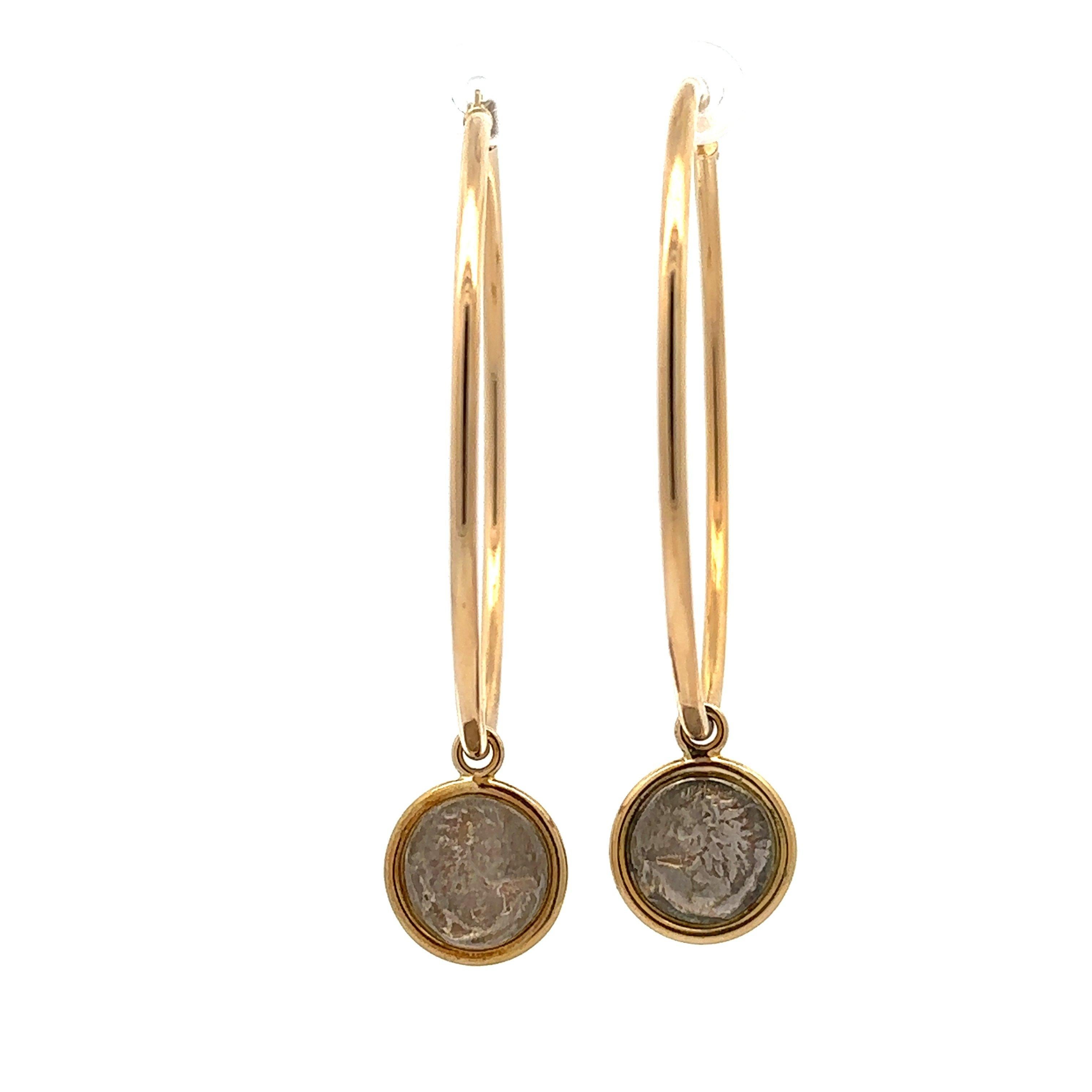 These signature Dubini hoop earrings are handmade in Rome and crafted in 18KT yellow gold. They feature bezel-set silver replicas of Thracian silver coins minted circa 4th century B.C.  The large hoops measure 50mm in diameter x 2mm wide. The