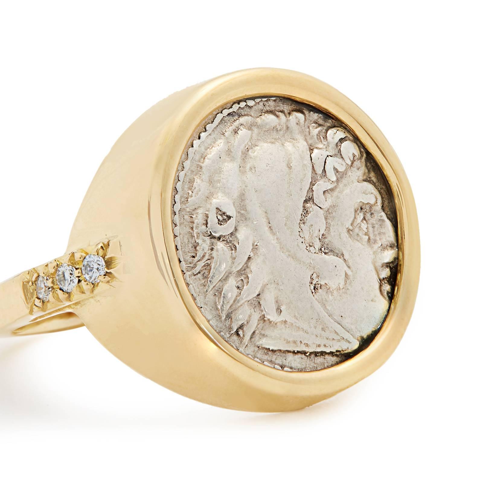 This DUBINI coin ring from the 'Empires' collection features an authentic Macedon silver coin minted circa 336-323 B.C. set in 18K yellow gold with diamonds.

DEPICTED ON COIN
Obverse: Head of Heracles right wearing lion's scalp; 
Reverse: Zeus