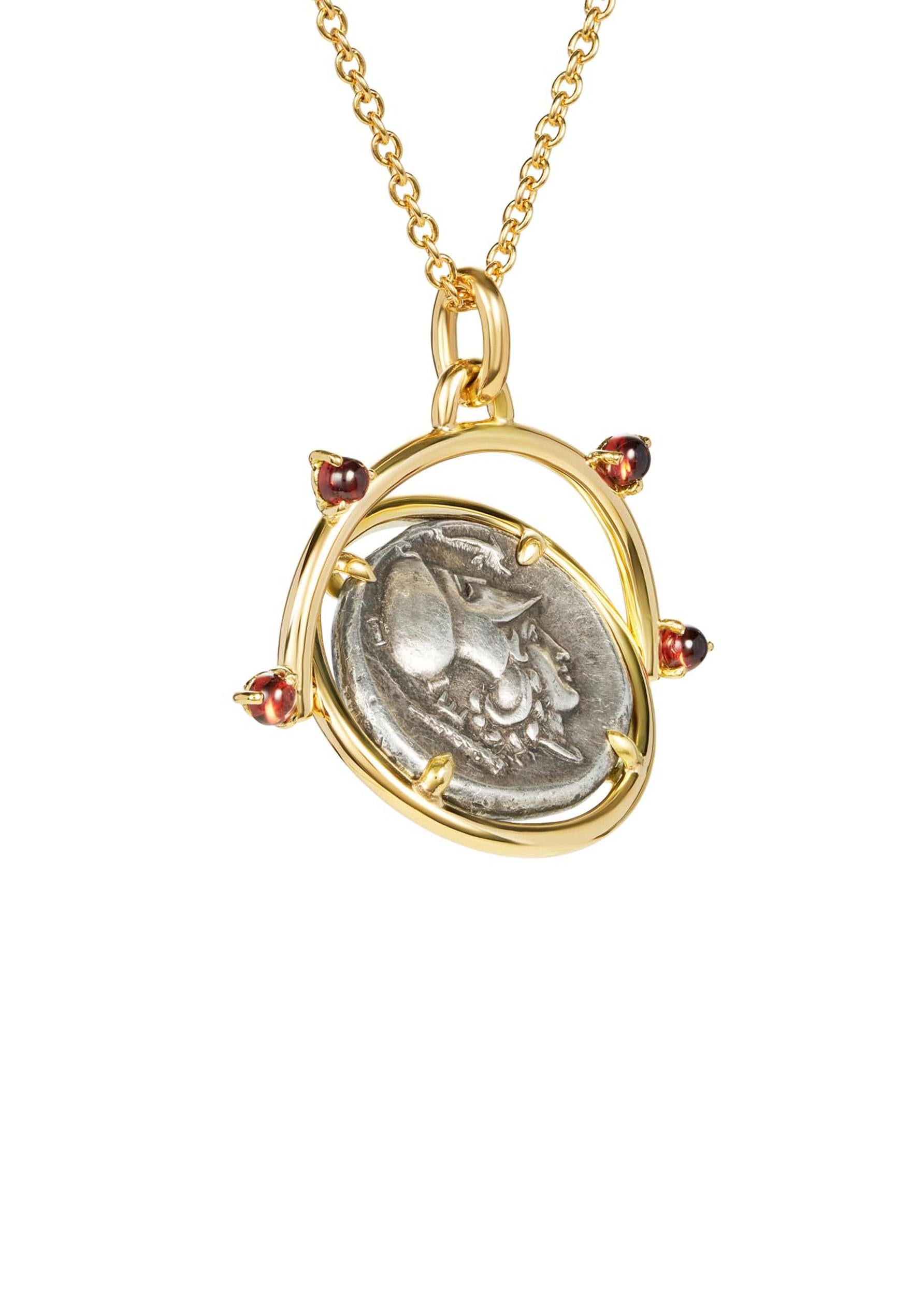 Questa collana DUBINI presenta un'autentica moneta d'argento di Atena, risalente al 338-250 a.C. circa, incastonata in oro giallo 18 carati con cabochon di granato.

DETTAGLI DELLA MONETA:
Dritto: Testa di Atena a destra, con elmo