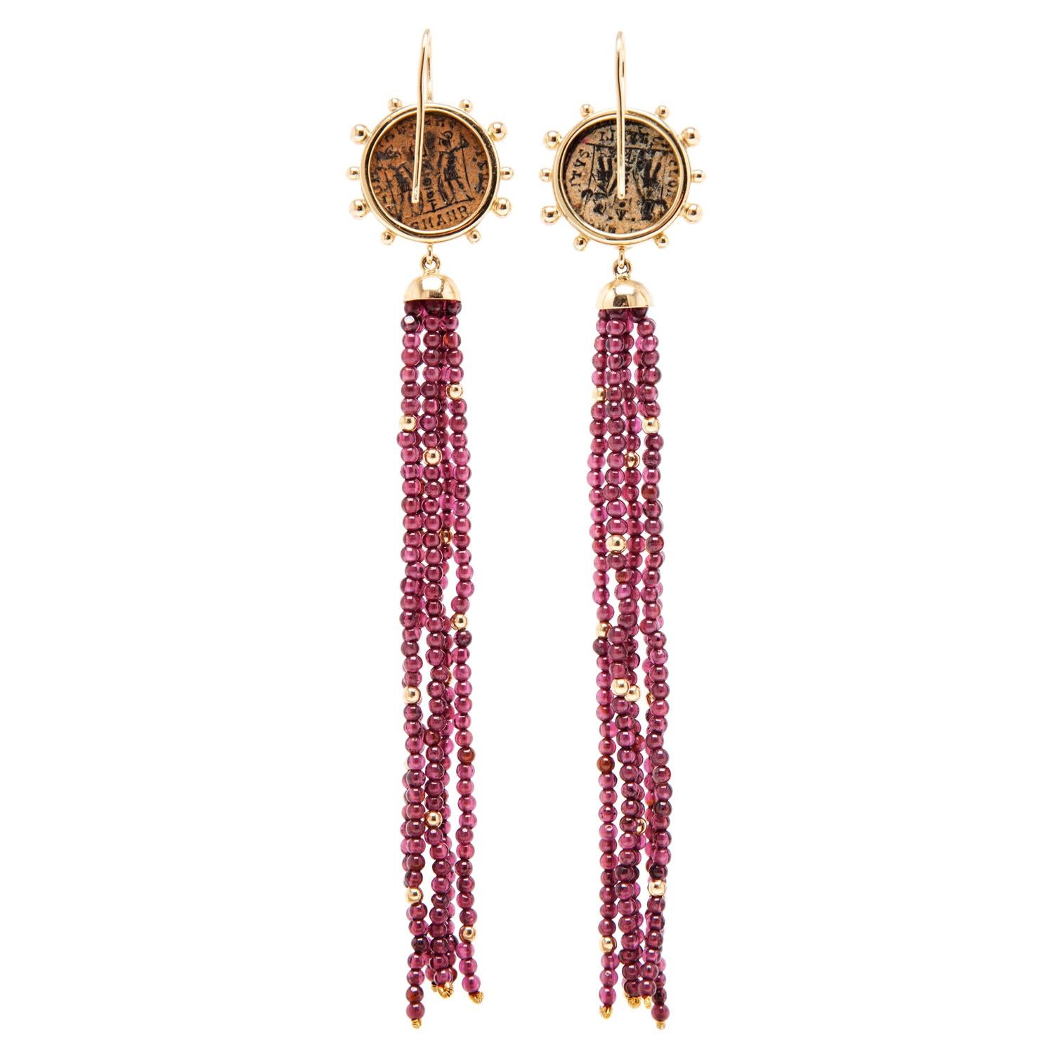 These Dubini coin earrings from the 'Empires' collection feature authentic Roman Imperial bronze coins set in 18K yellow gold with garnet and gold beaded tassel.

* Due to the unique process of hand carving coins in ancient times, there may be a few