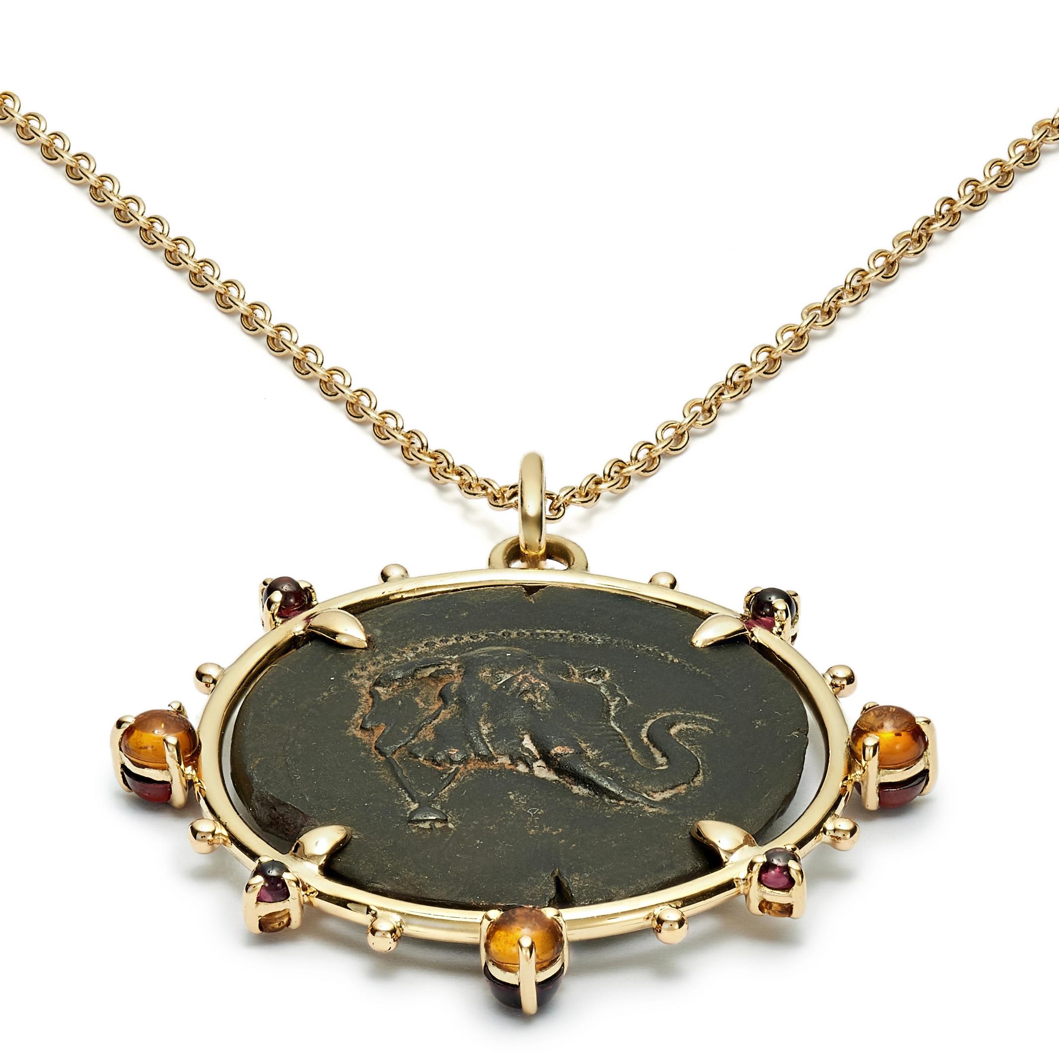 This DUBINI coin necklace from the 'Empires' collection features an authentic silver coin from the Greco-Baktrian Kingdom dating circa 200-185 B.C. set in 18kt yellow gold with citrine and garnet cabochon.

Depicted on the coin: 
Obverse - Head of