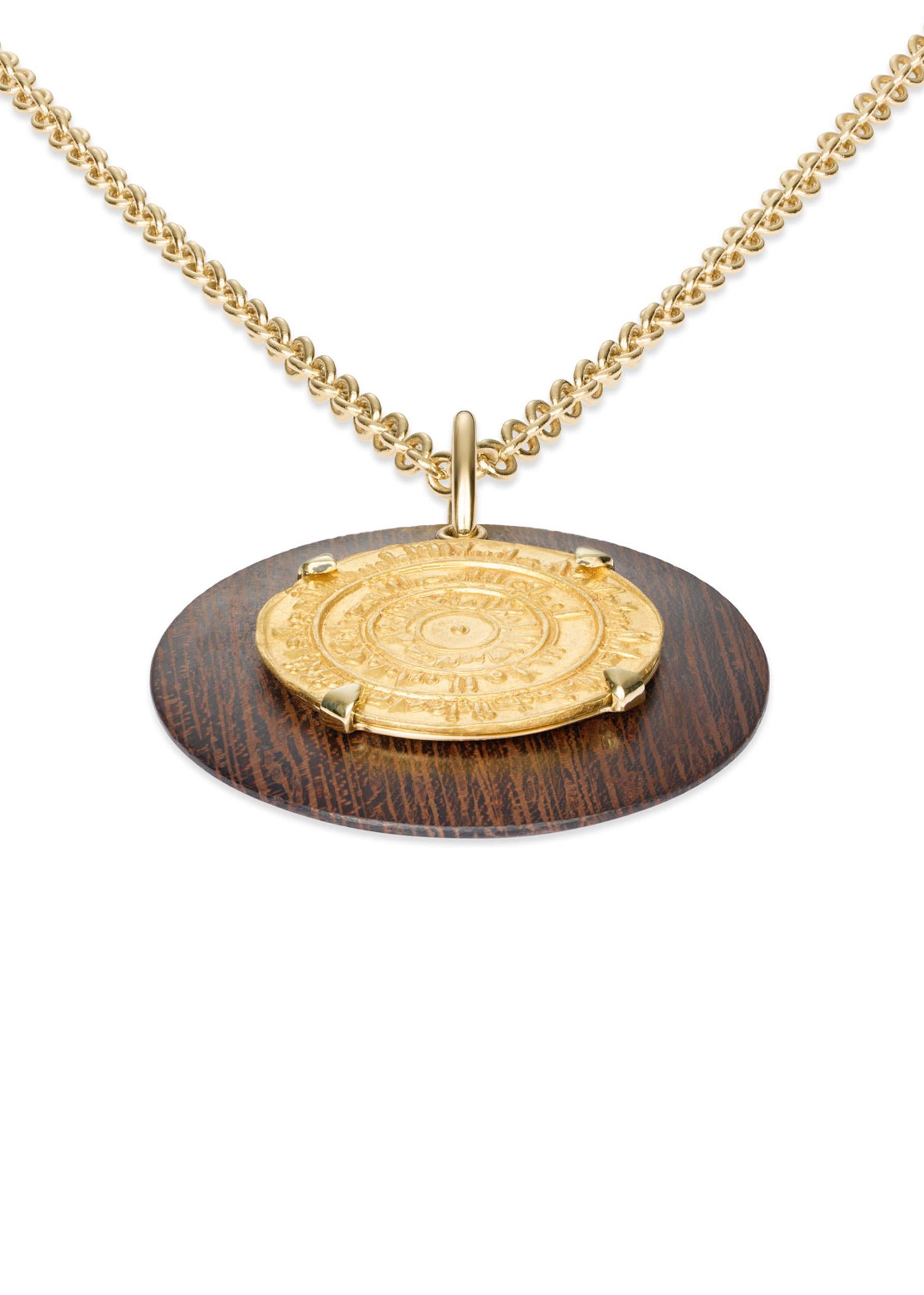 *RARE* This exquisite DUBINI necklace showcases an authentic gold dinar coin set in 18K yellow gold with wenge wood disc.

COIN SPECIFICATIONS:

- Diameter: Ø 22mm
- Minted: Circa A.D. 1055

HISTORY:

This bulls-eye type coin, minted under