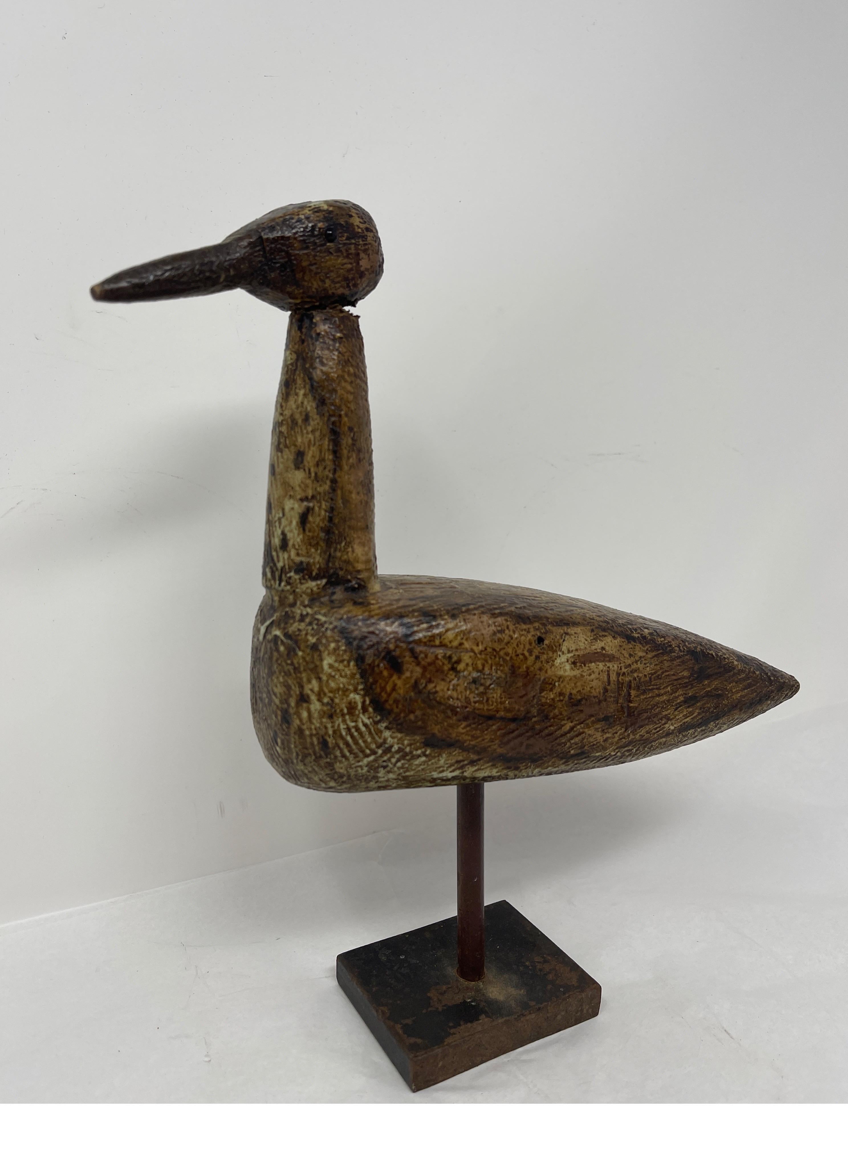 Made to look like a loon bobbing on a lake this vintage duck decoy on a custom stand would make a hunter's study complete. The decoy is carved 
 in wood and mounted on an iron stand. The stand is removable and the bird's head swivels.

Measures: