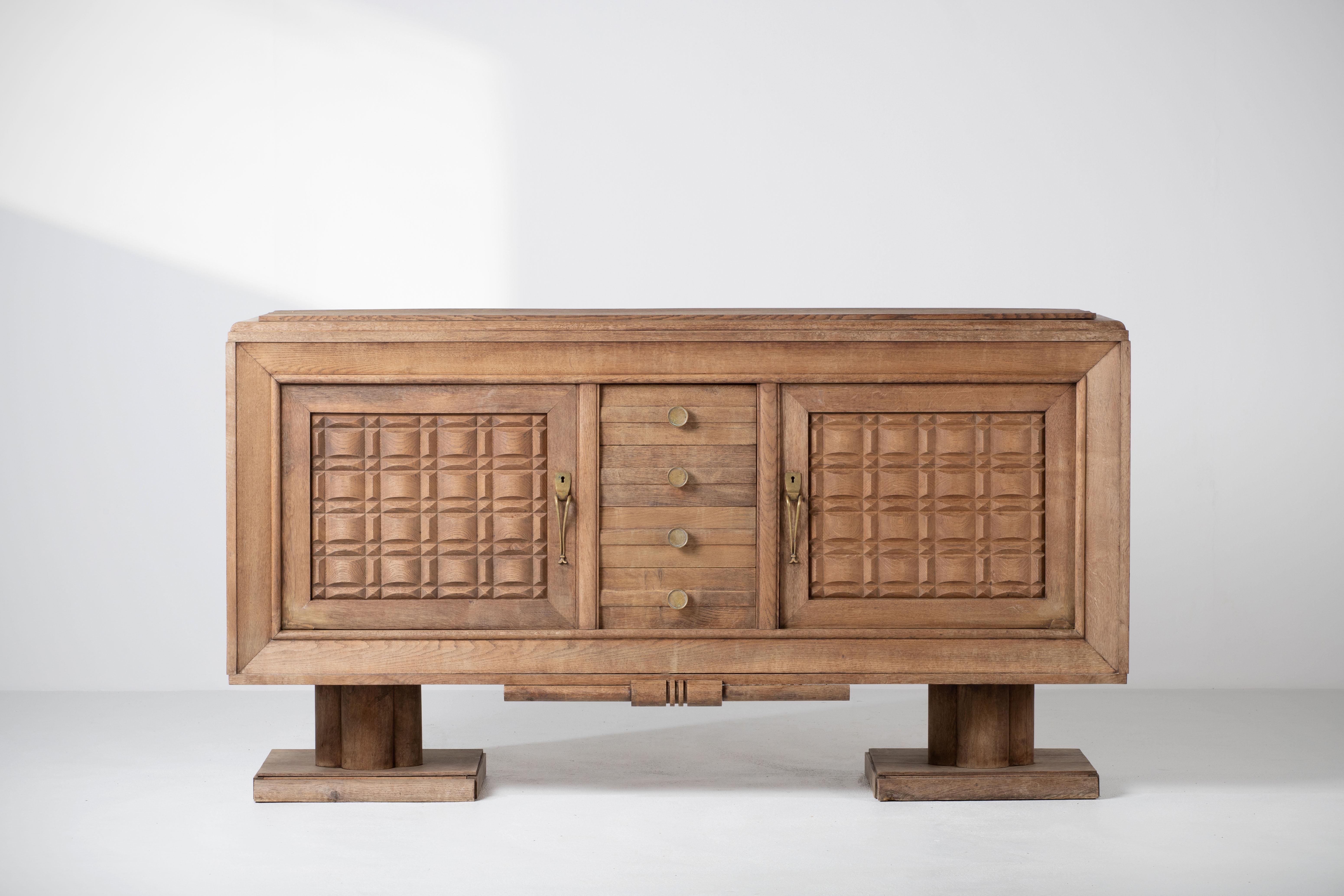 Credenza, solid oak, France, 1940s, attributed to Charles Dudouyt.
Large Art Deco Brutalist sideboard in a bleached finish. 
The credenza consists of two storage facilities and three drawers. It is covered with very detailed designed door panels.