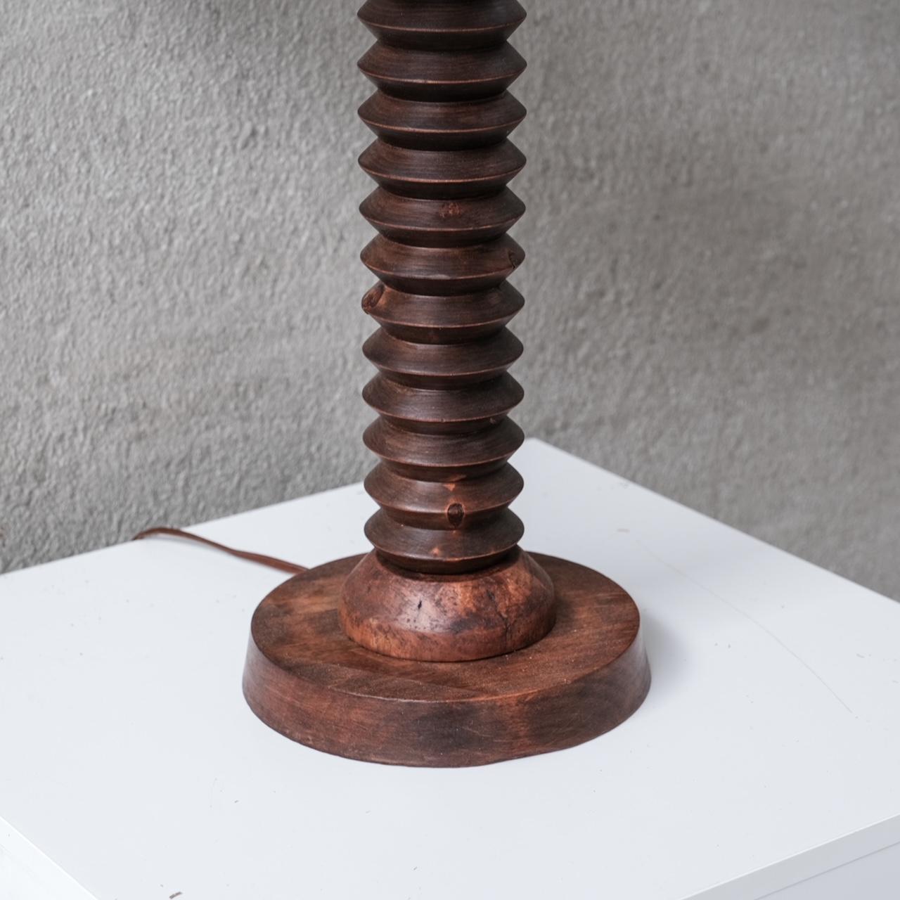 A turned oak table lamp.

France, c1940s.

Paired with a new shade.

Since re-wired and PAT tested.

Good vintage condition, some nicks and wear commensurate with age.

Location: Belgium Gallery.

Dimensions: 59 H x 35 Diameter in cm.

Delivery: