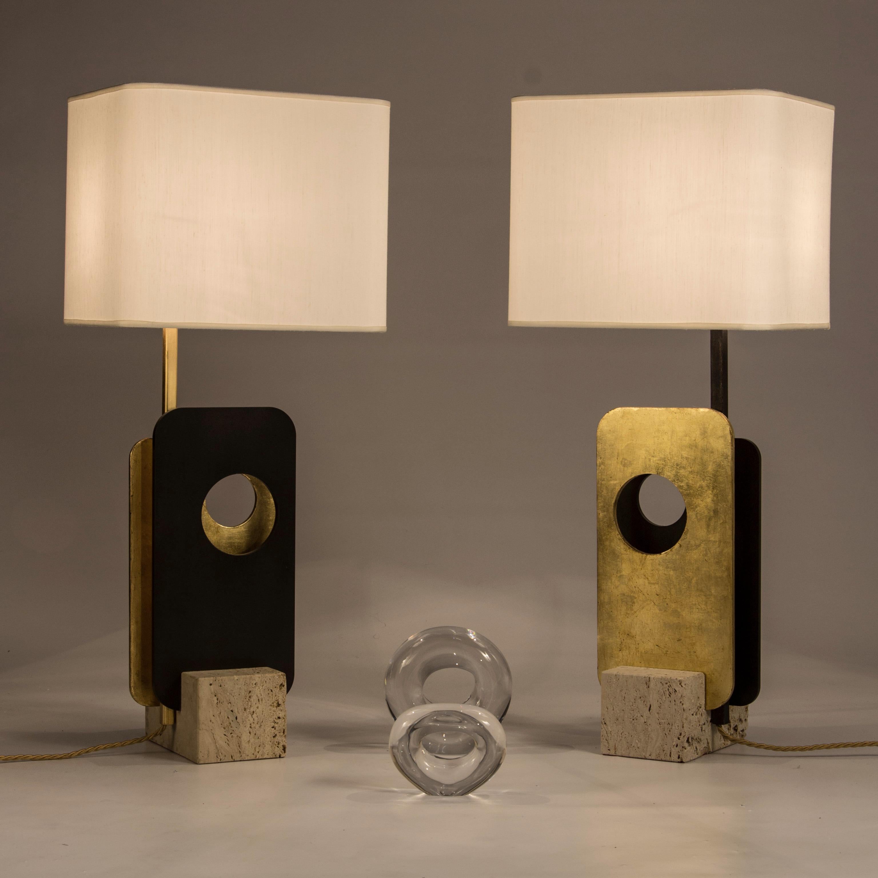Lamp with structure consisting of two iron plates: one is decorated in gold leaf, the other in natural waxed iron. The plates are housed in a marble base (it is possible to choose polished travertine or white Carrara marble). The ivory-colored