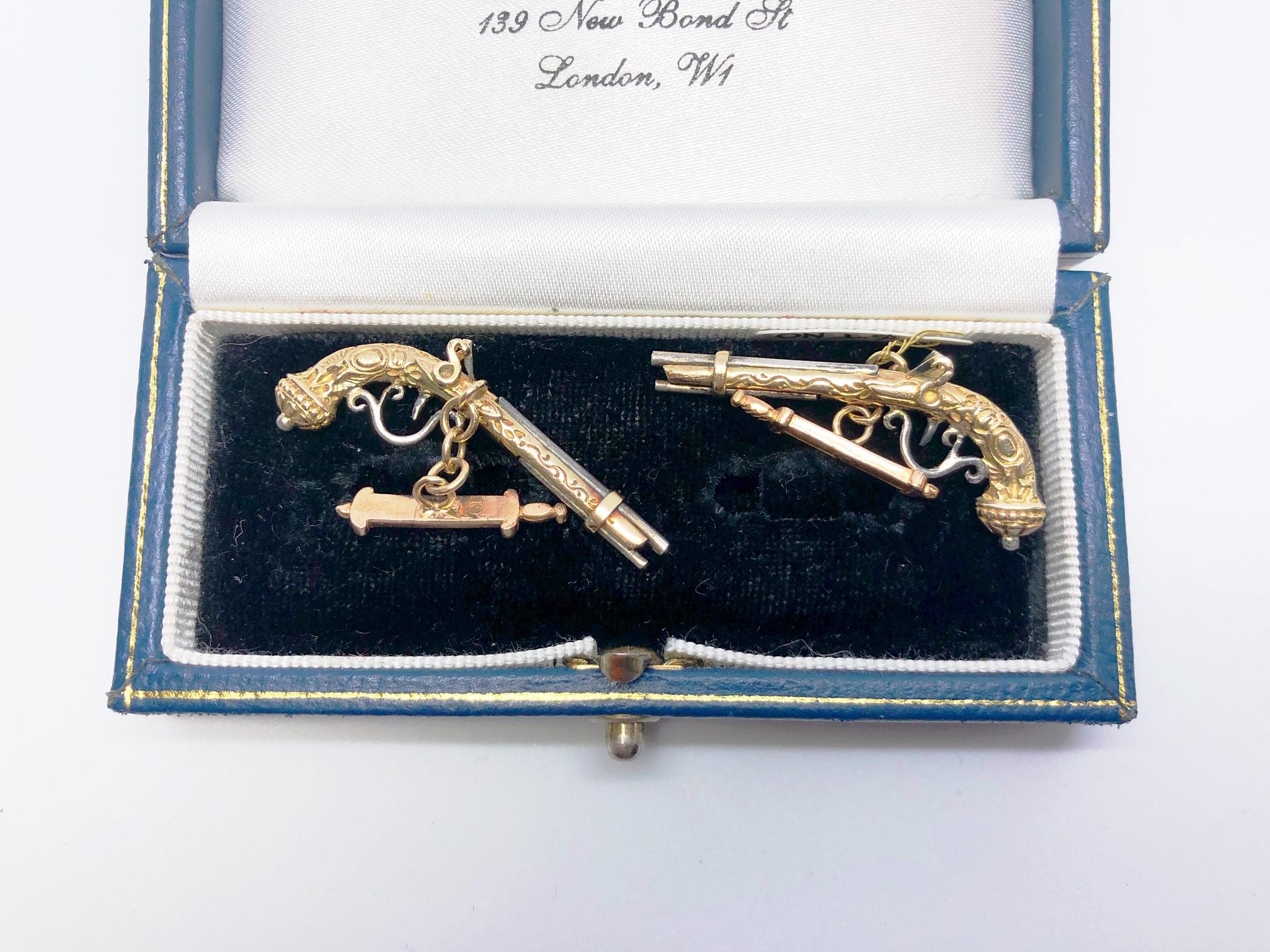 A pair of duelling pistol cufflinks, with engraved decorations, mounted in 14ct yellow and white gold, with chain link connection. Measures approximately 35 x 17.3 x 5mm.