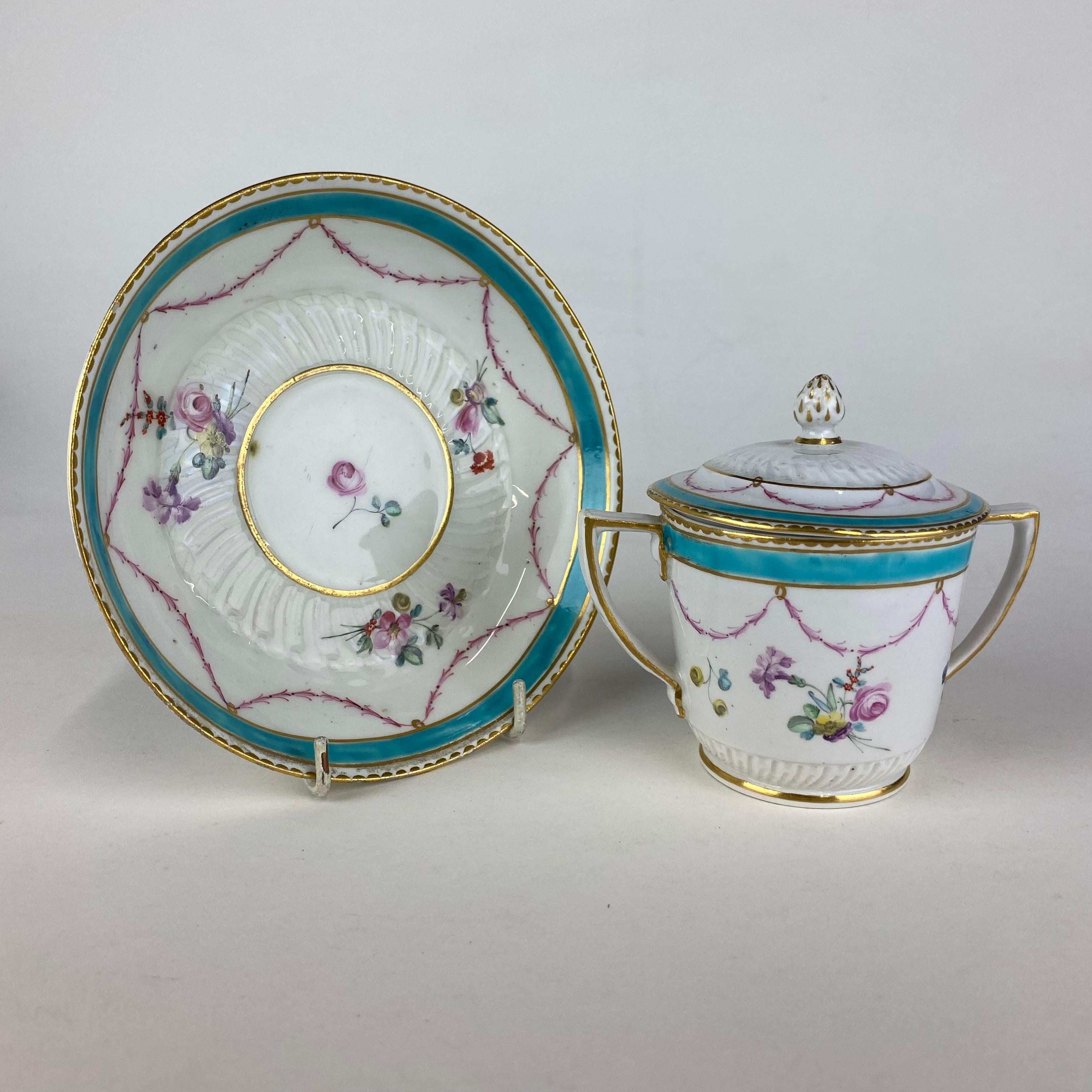 Deliziosa tazza per cioccolata a due manici Duesbury Derby, con coperchio e supporto, decorata in smalti policromi con ghirlande di fiori.