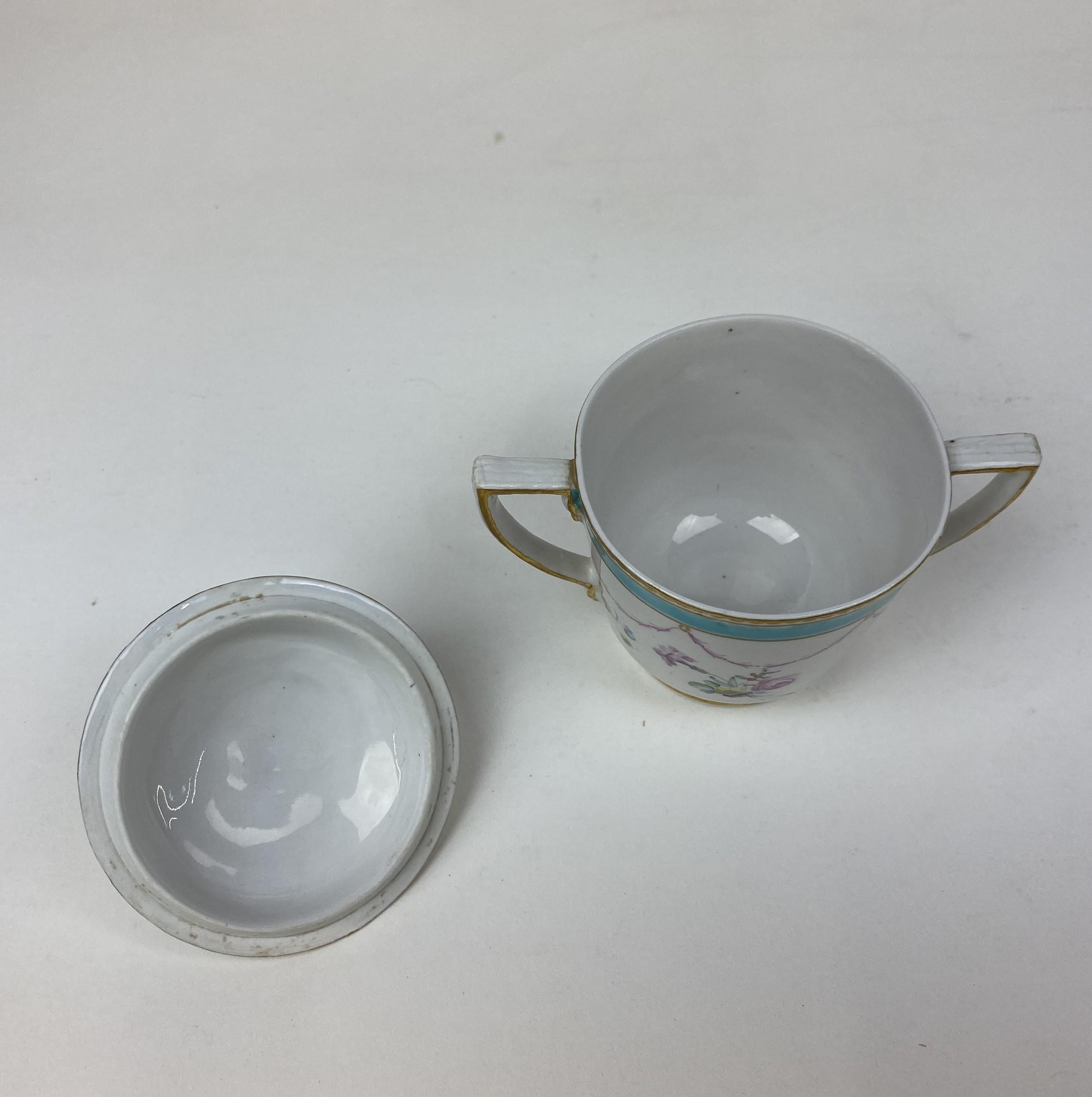 Tazza e piattino in porcellana Duesbury Derby, circa 1765. Decorato nello stile di Serves con spruzzi e bouquet di fiori europei e un bordo a pois turchesi con doratura a traliccio. La tazza con manico ad anello ritorto.