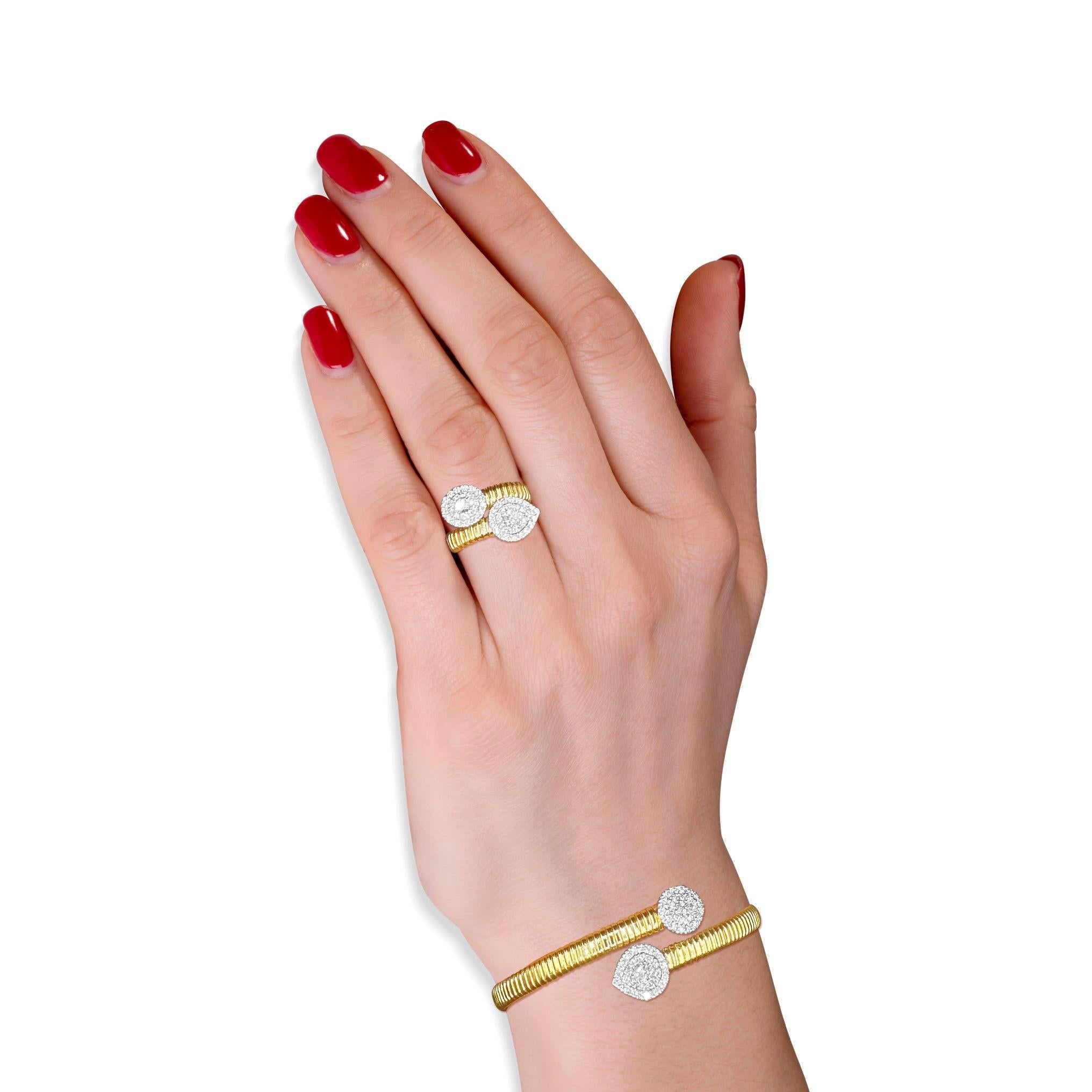A striking balance of brilliance and elegance, the Duet Diamond Halo Bypass Ring showcases a stunning interplay of shape and sparkle. Crafted in luxurious 18K yellow gold, this sophisticated design features a pear-shaped and an oval-shaped diamond,