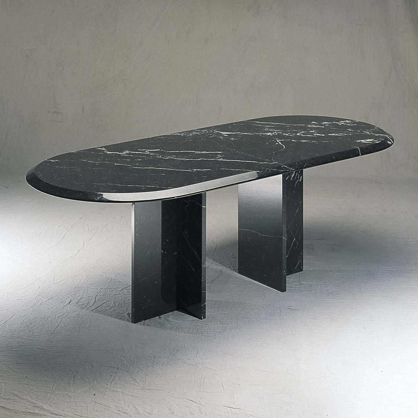 Designed by Achille Castiglioni in 1990, the simple and essential geometry of this table combined with the precious marble create a stunning visual impact. Made entirely of black Marquinia, the elliptical bevel edged top is supported by two T-shaped