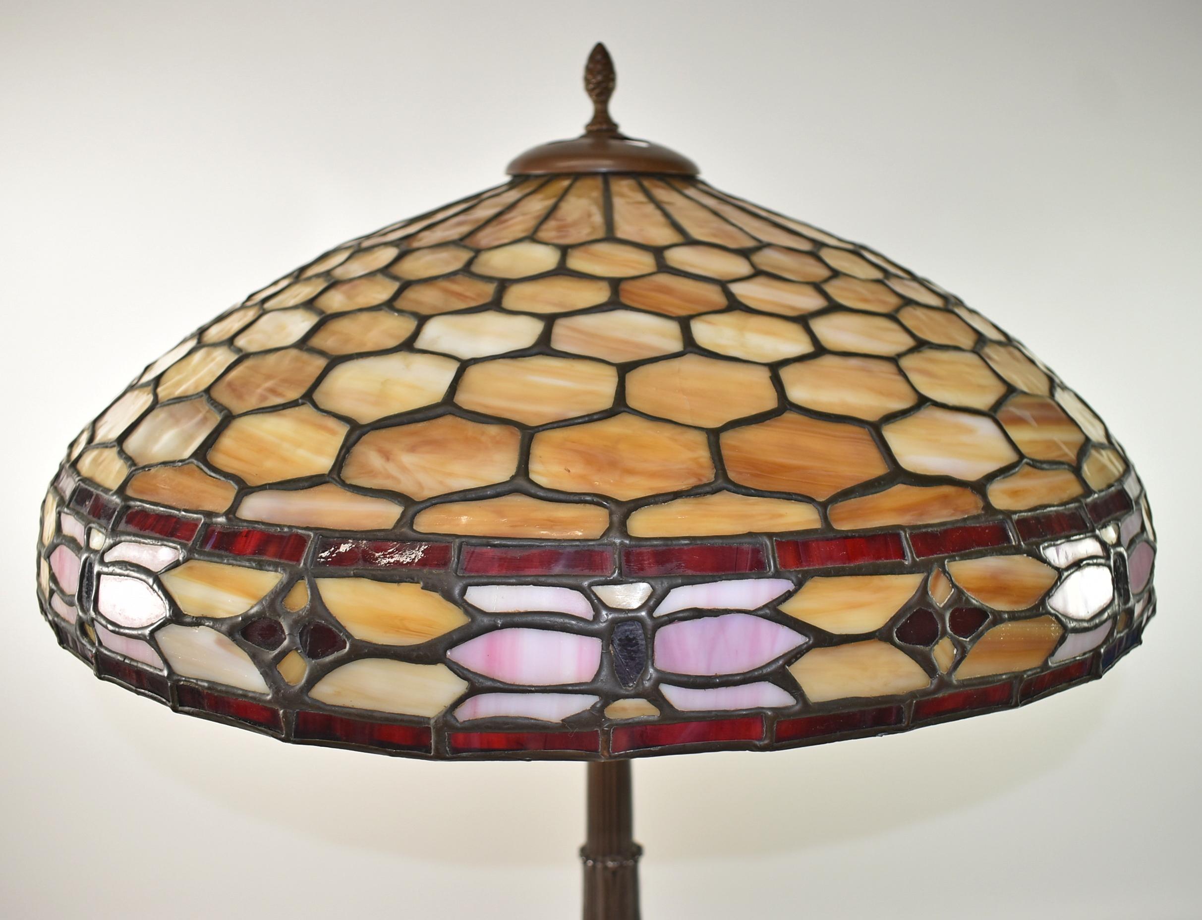 Duffner & Kimberly leaded stained glass and bamboo table lamp, circa 1920s. Honeycomb design with pink floral band edged in red with 3 loops inside shade and 6 tight cracks. Heart design cut into cap. Petal or leaf design and ball pulls. Bronze