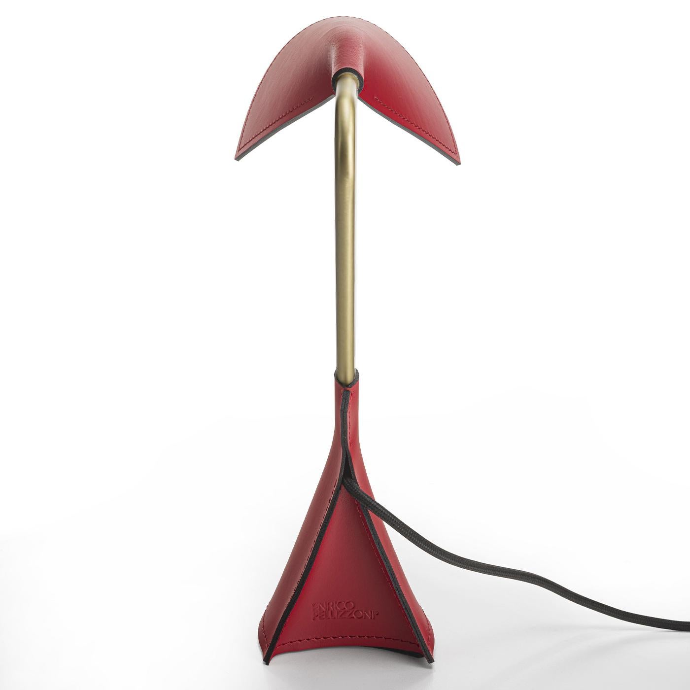 A striking accessory to a modern desk or nightstand, this desk lamp features a satin brass structure and an eye-catching red leather base and shade with tone-on-tone stitching. Elegant and sophisticated, the shade is detailed with a black edge,