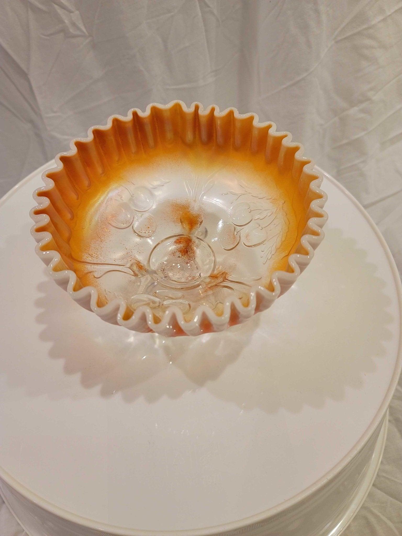 Unique white and orange (Peach Glass) antique folded dish that sits upon 3 legs. There are raised glass details of cherries on the underside that show through to the inside bottom of the bowl. Flawless.

Formed to a 6-3/4