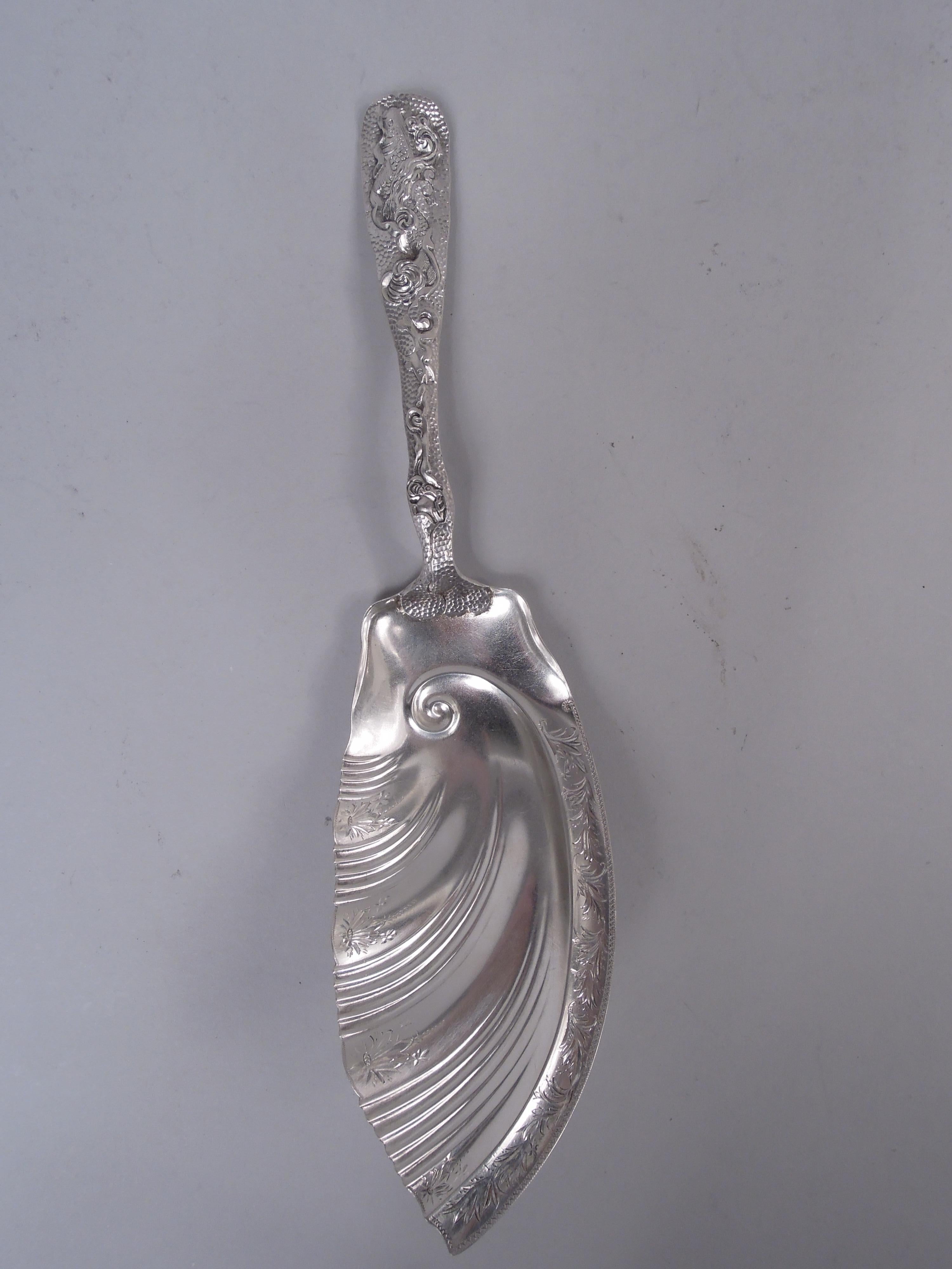 Japonesque sterling silver fish serving fork and slice. Made by The Duhme Company in Cincinnati, ca 1885. Handles shaped and tapering with fish and crabs in scrolled current; stippled ground. Shank scrolled and blade shaped and fluted; bright-cut