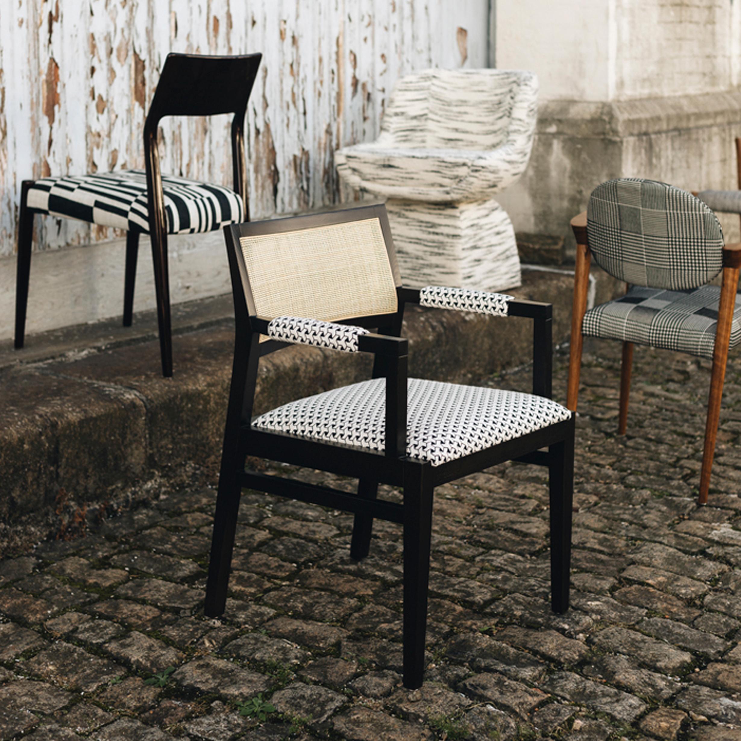 Duistt Basic 1.1 Chair by Duistt
Dimensions: W 56 x D 56 x H 81 cm
Materials: Guell Lamadrid - SF.DE.21.003 Fabric, White French Cane, Darkened Ash wood

Duistt Basic 1.1 floats a well-padded seat between two arched arms that recall the classic