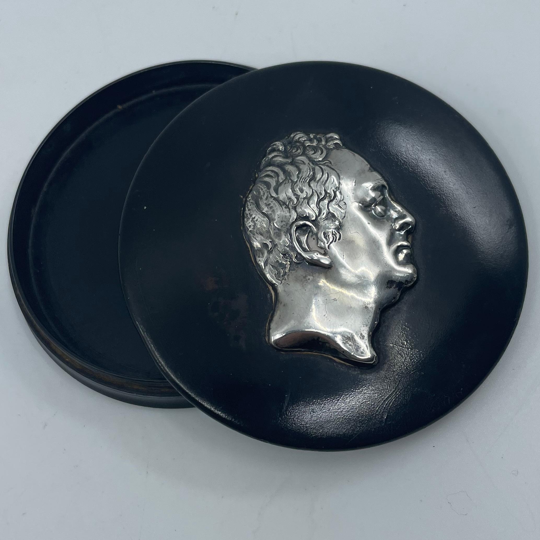 Duke of Clarence sterling silver snuff box. Antique ebonized wood and sterling silver box with the profile of the son of Queen Victoria. England, late 19th century. 
Dimensions: 3.5” diameter x .75