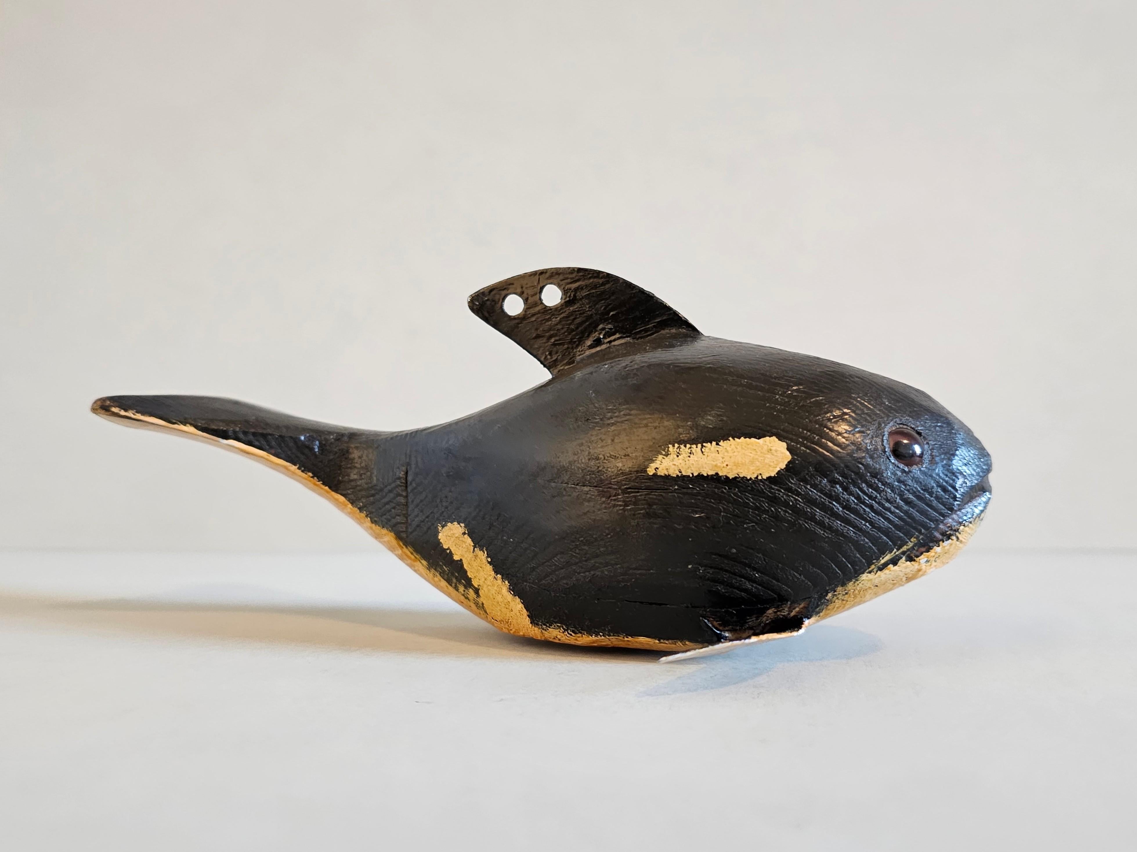A scarce early Duluth Fish Decoy American folk art sculpture, depicting a Orca killer whale, hand-carved by the late David Earl Perkins (Duluth, Minnesota, 1934-2018), featuring the realistic original hand-painted black finish with cream white