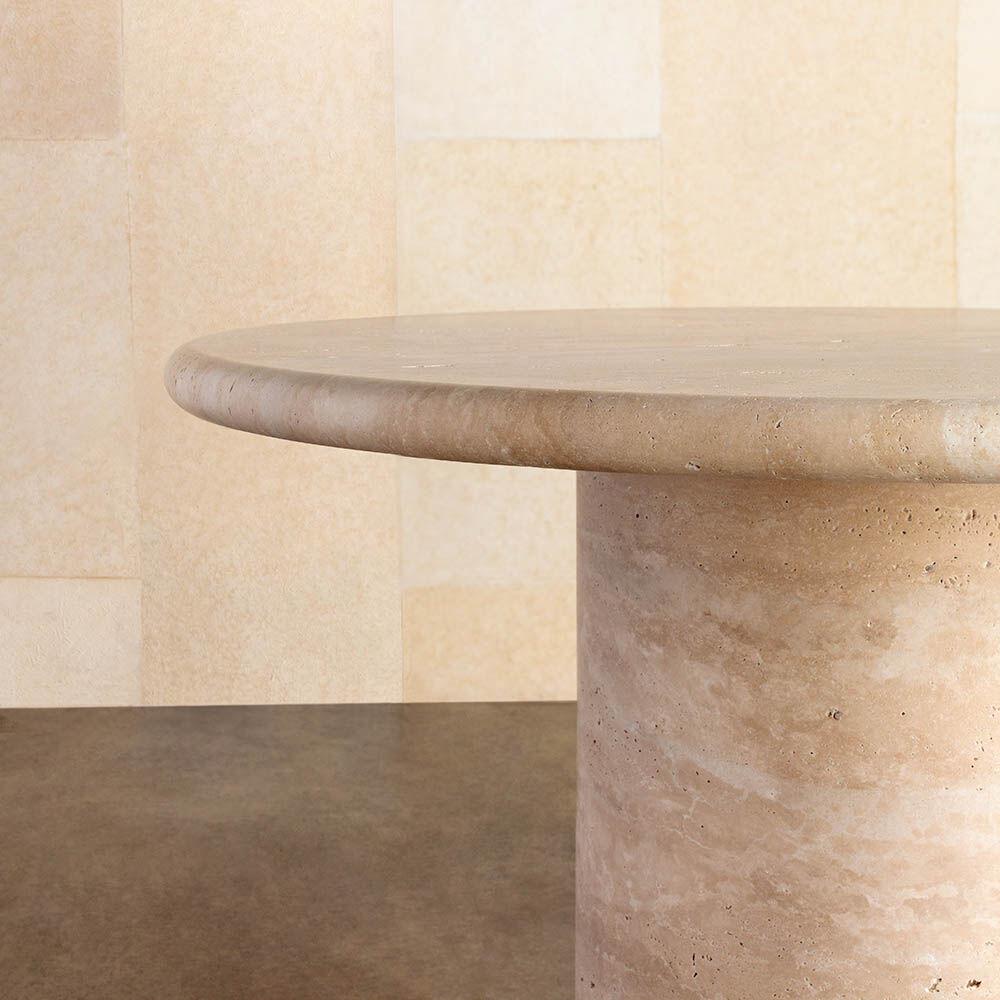 This pedestal table is carved from a hand selected travertine block. The soft bull nose edge of the tabletop creates an unexpected contrast to the raw travertine material. This table in 48