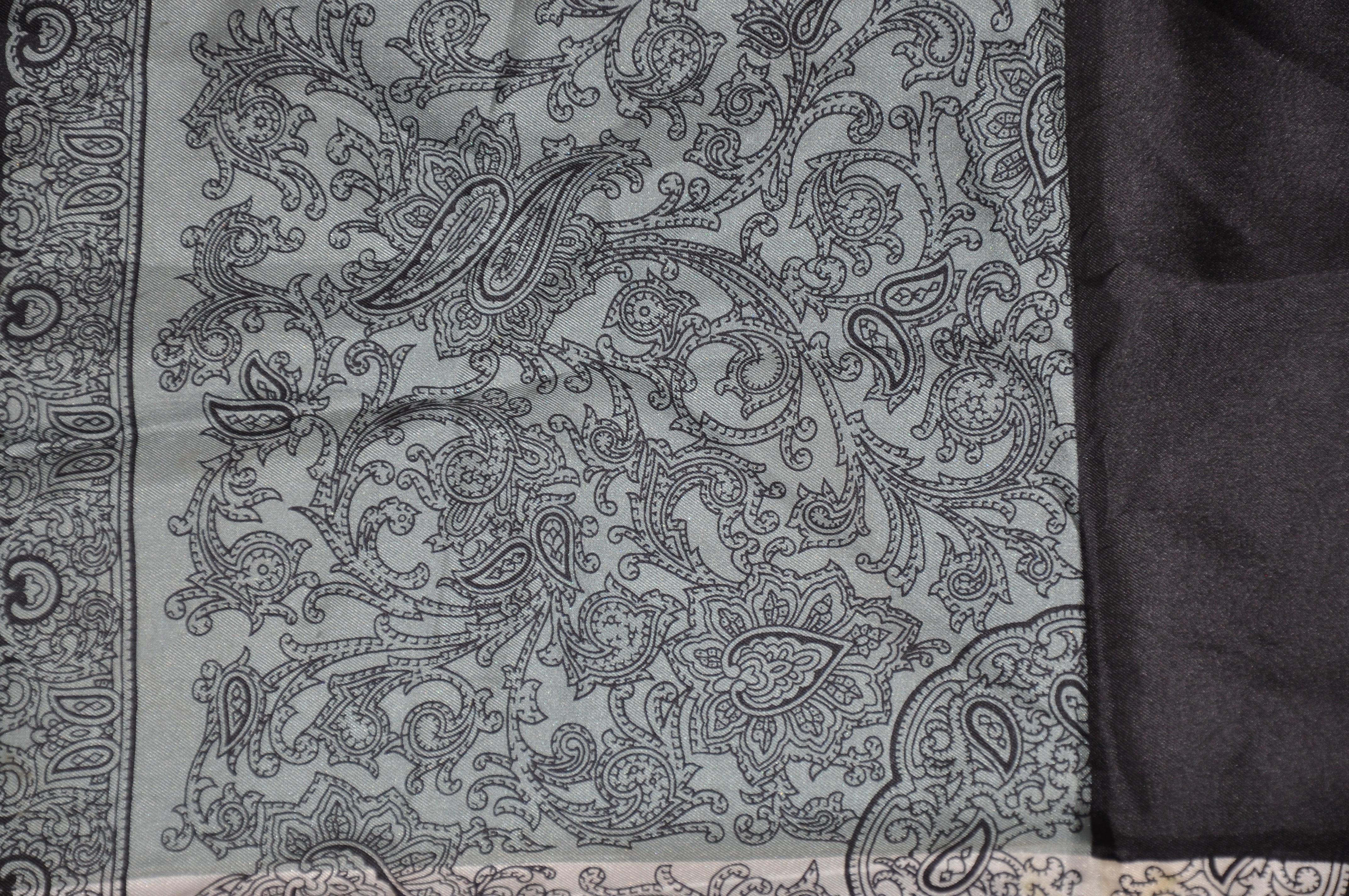        Mouchoir en soie Dumont à l'élégante bordure noire entourant l'ivoire, le gris et l'acier palsey, accentué par des bords roulés à la main, mesure 16 pouces par 16 pouces. Fabriquées en Italie.