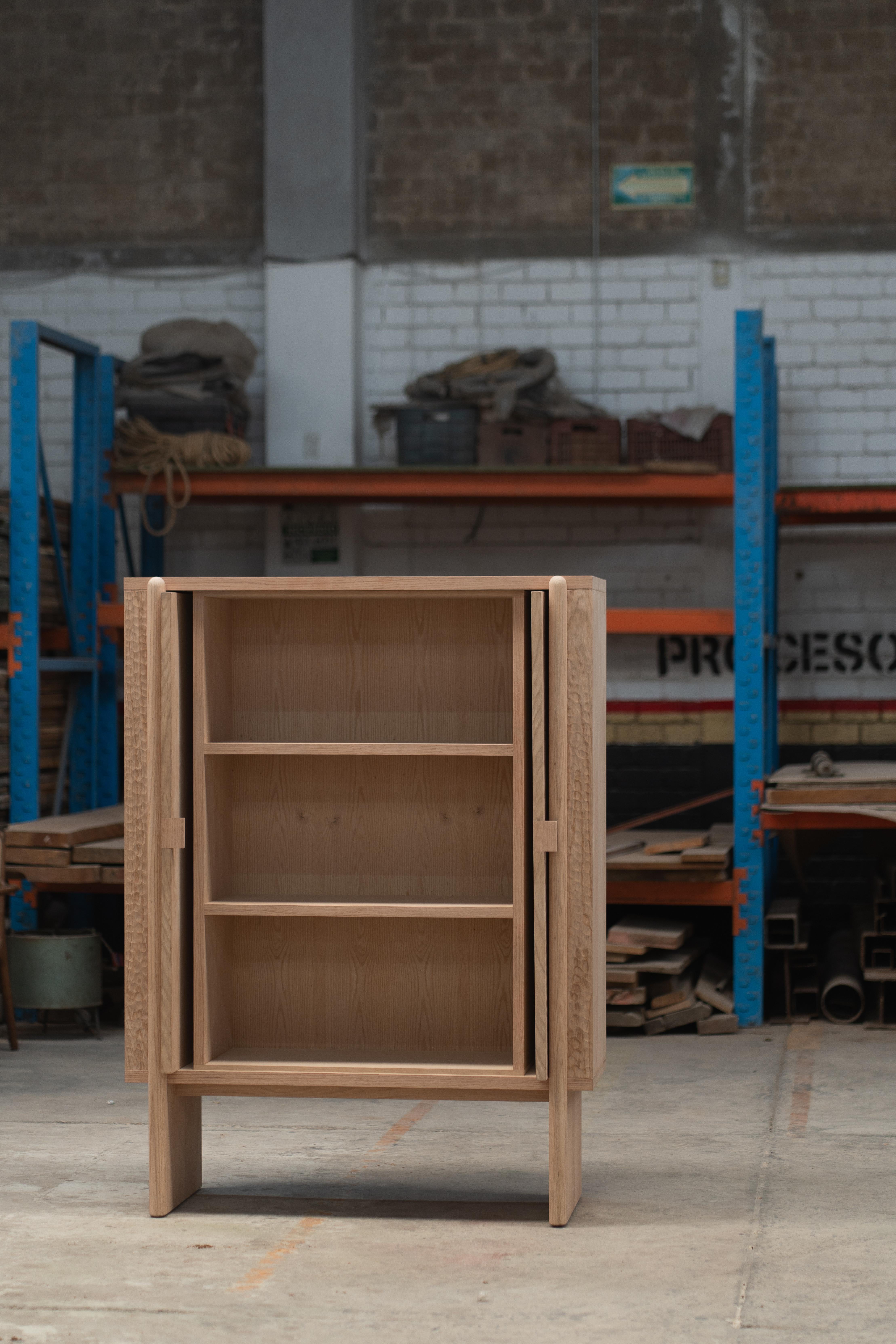 The Duna armoire is a handcrafted piece made from oak. Its detailed, hand-carved solid wood facade reveals exceptional craftwork that highlights the grain and texture of the oak that makes each armoire unique. Inside, there are adjustable shelves